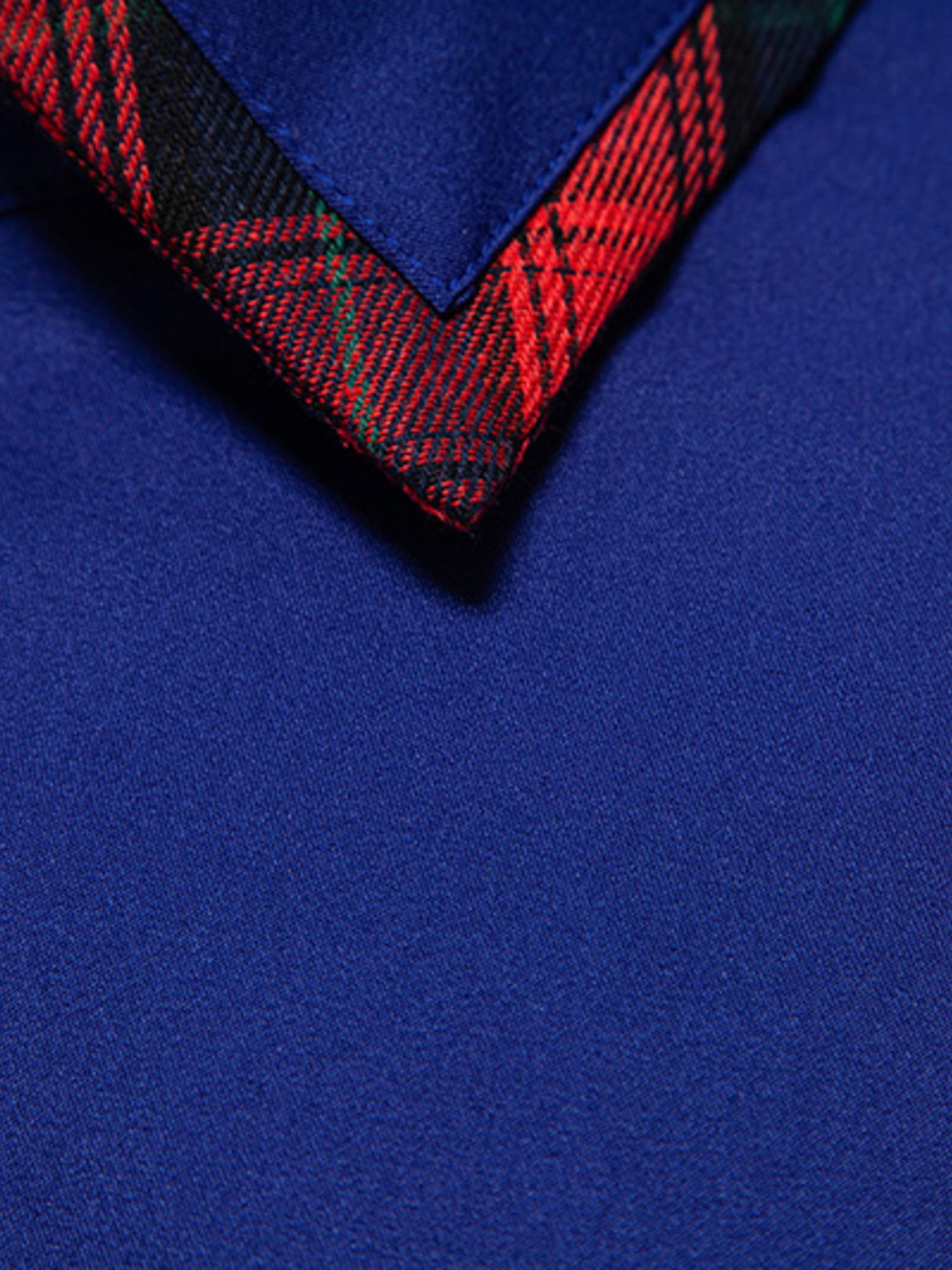 Close-up of a blue fabric with a red and black checkered border