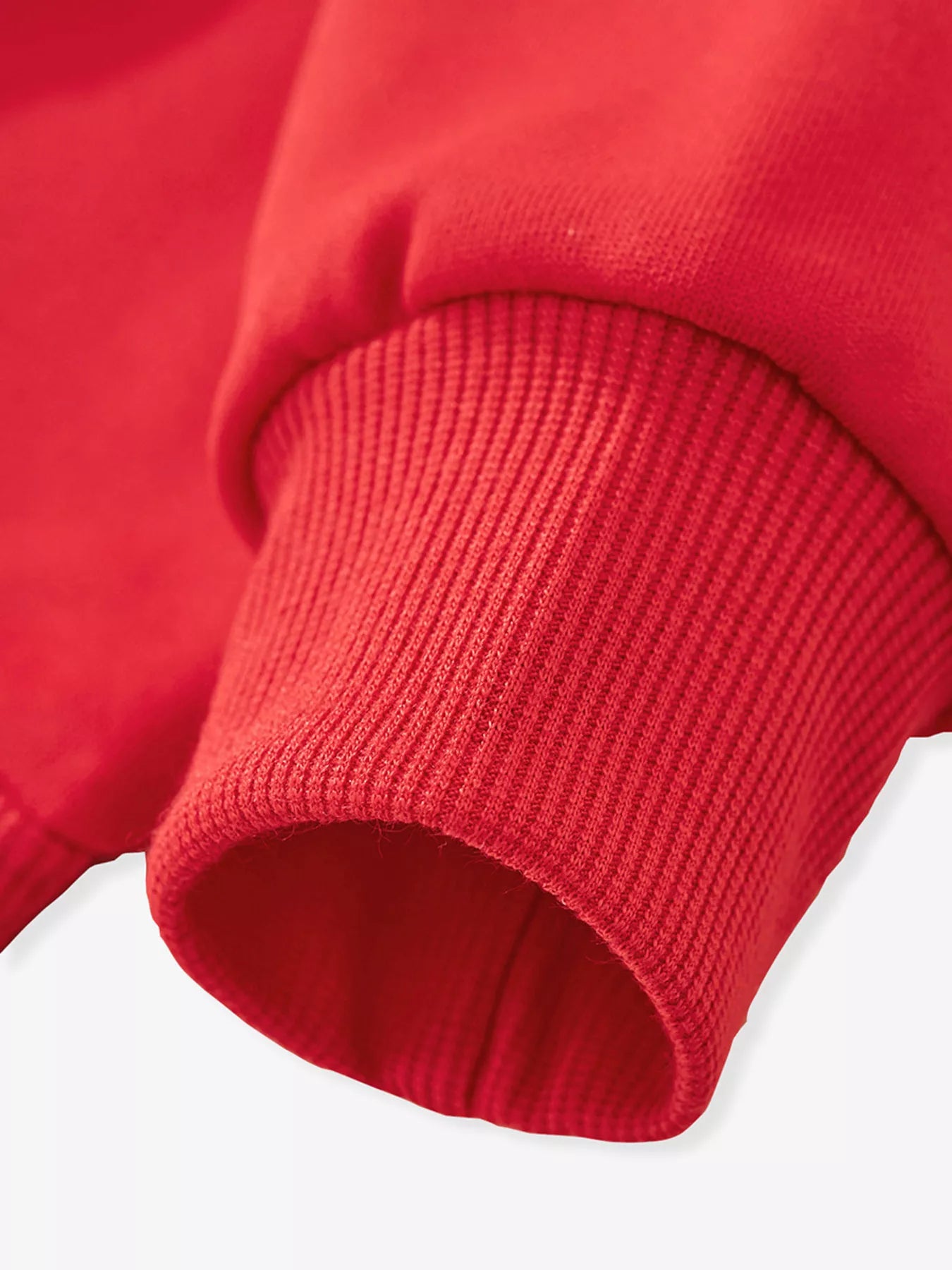 Close-up of a red sweater sleeve on a white background
