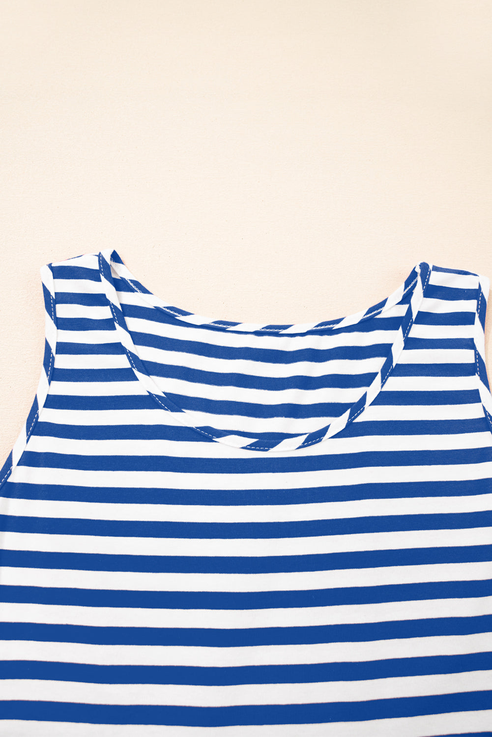 Blue and white striped tank top on a beige background