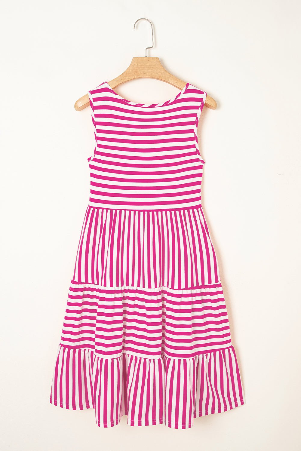 Pink and white striped dress on a hanger against a white background