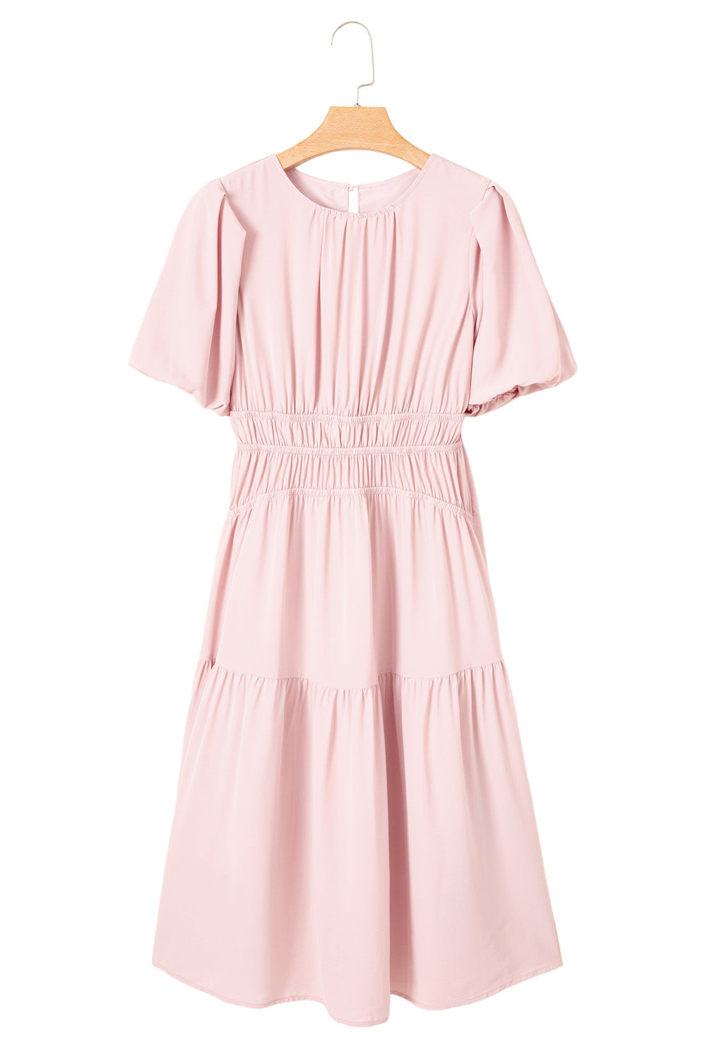 Pink dress on a wooden hanger against a white background