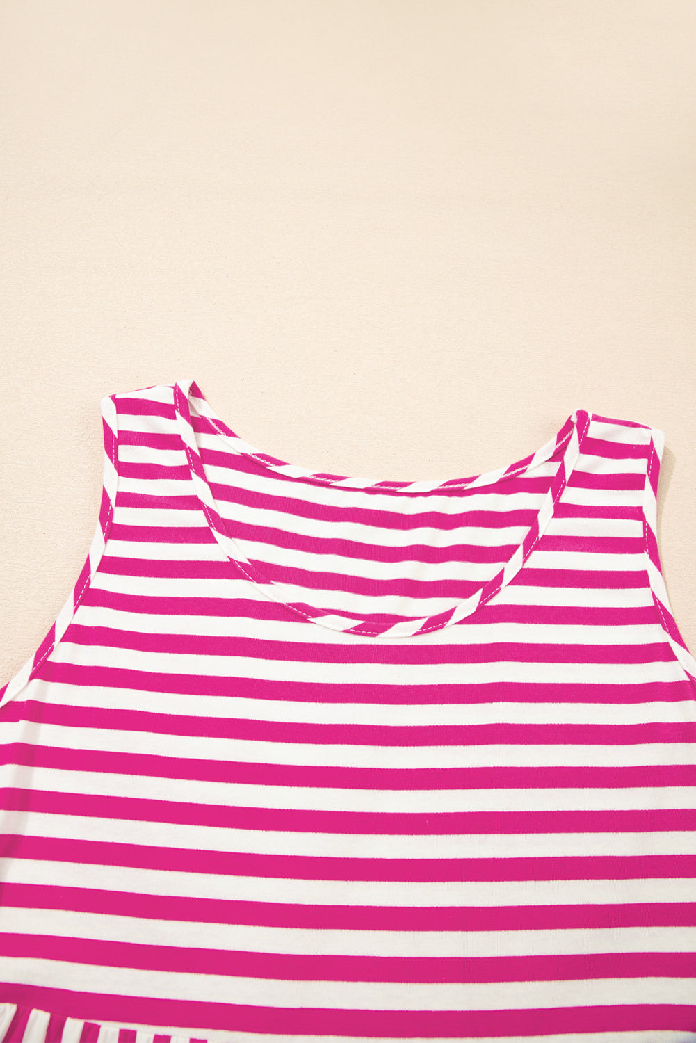 Pink and white striped top on a beige background