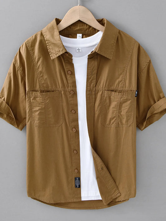Brown short-sleeve shirt on a hanger against a gray background