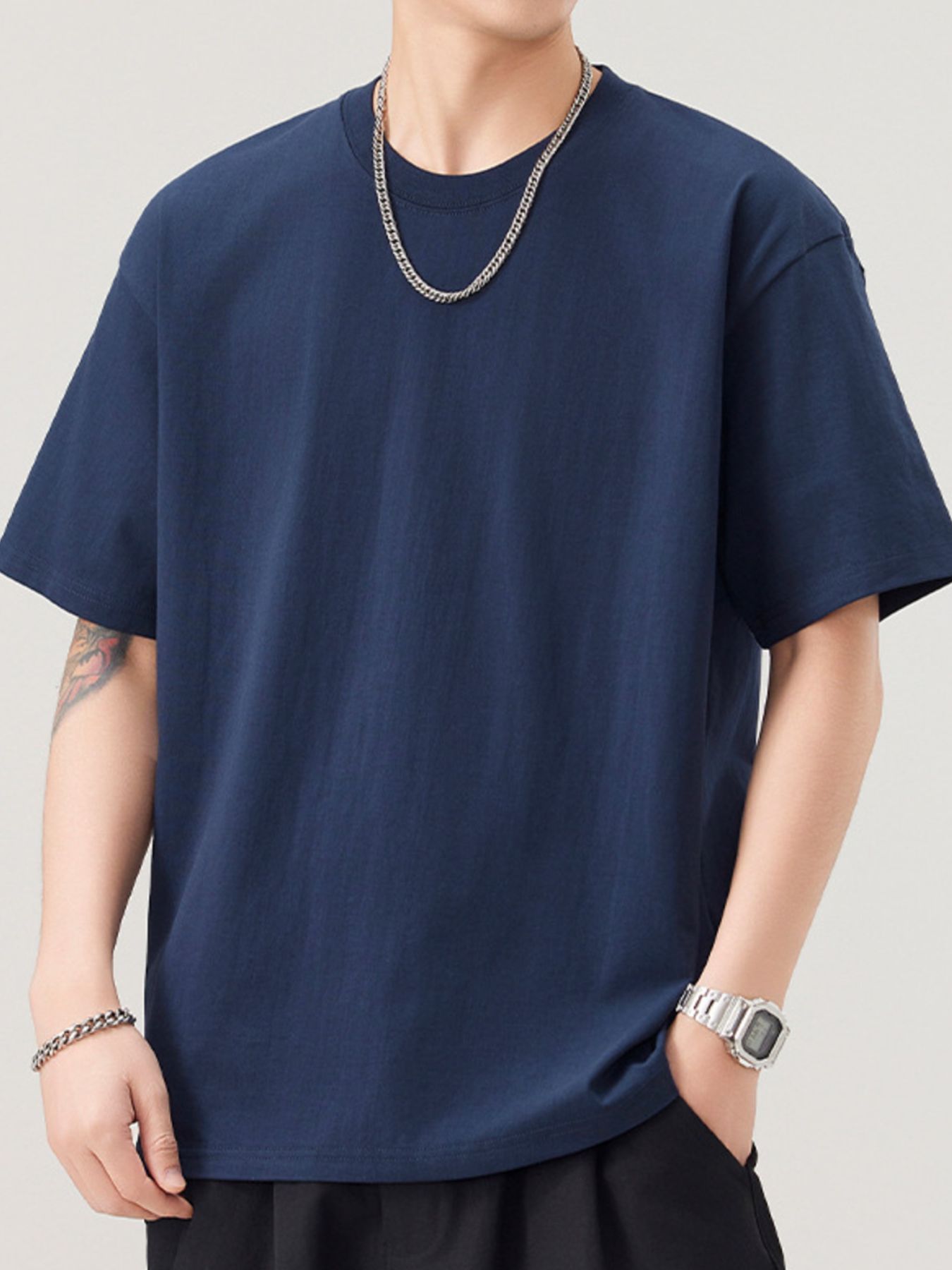 Person wearing a navy blue t-shirt with a plain background