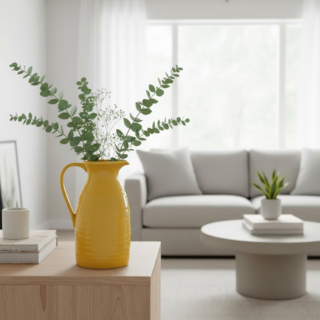 Yellow vase with greenery on a wooden table in a modern living room.