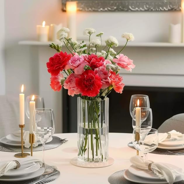 Decorative table setting with flowers, candles, and glasses in a cozy room.