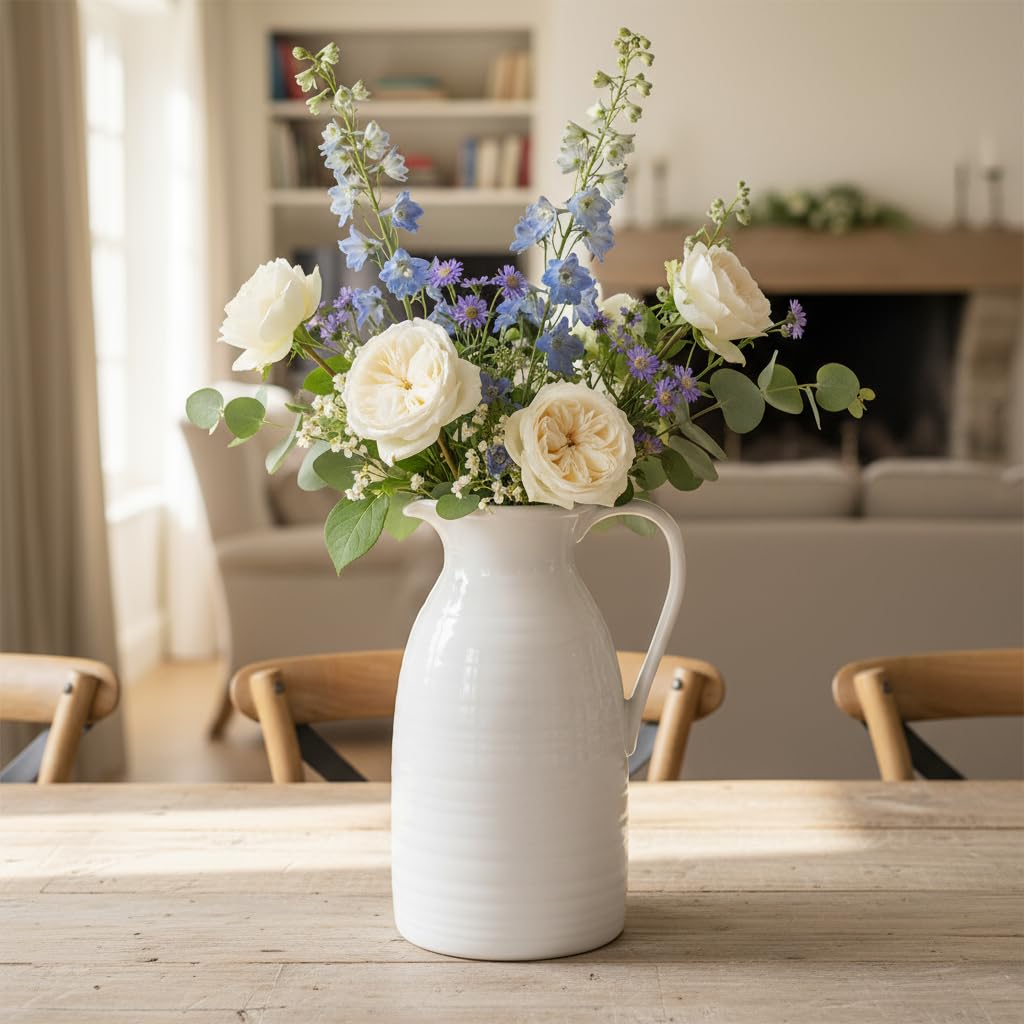 White vase with flowers on a wooden table in a living room setting