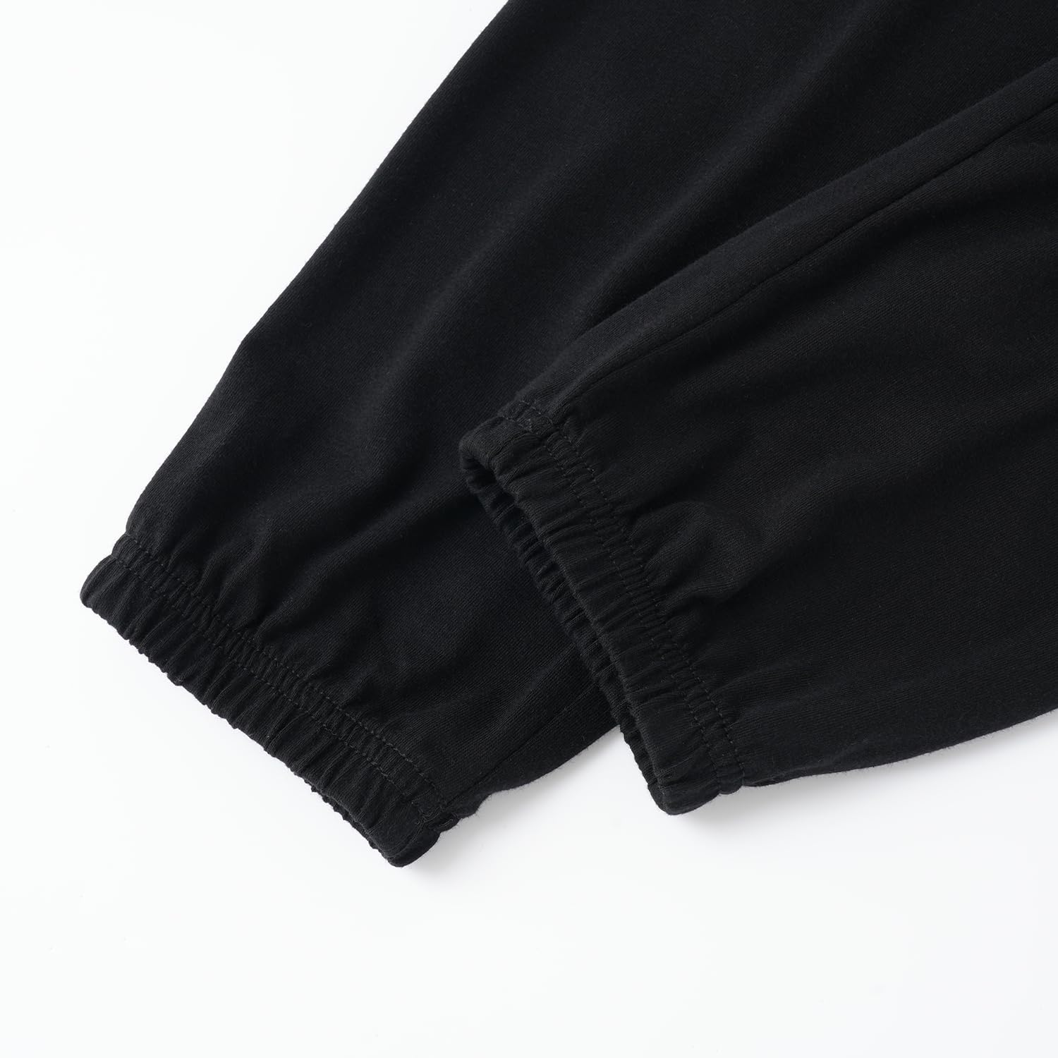 Close-up of black pants with elastic waistband on a white background