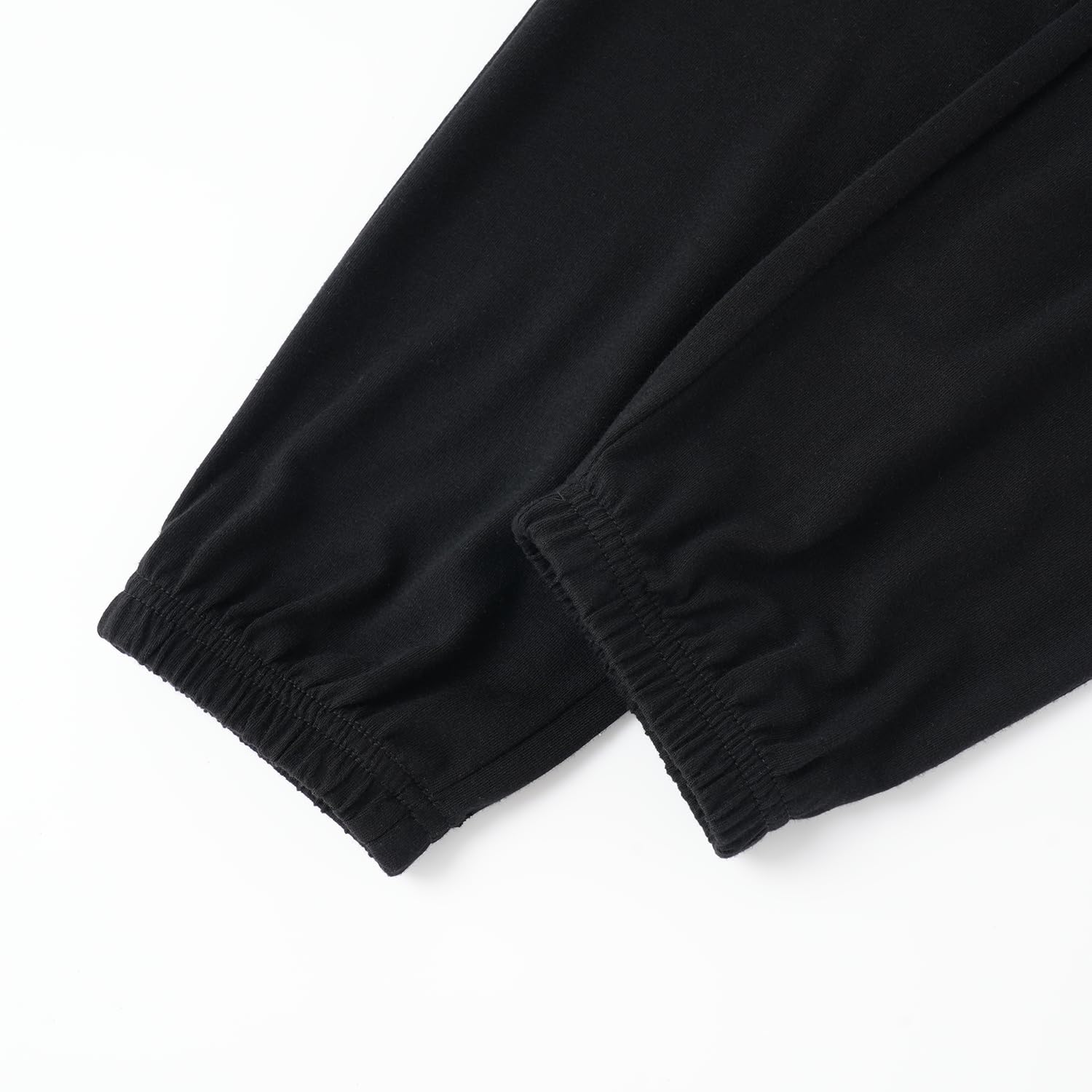 Close-up of black pants with elastic cuffs on a white background