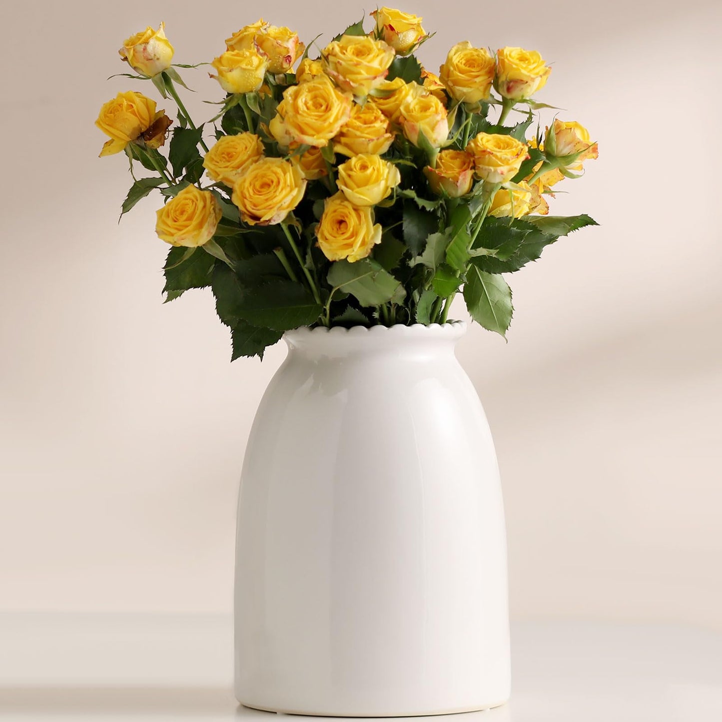 Bouquet of yellow roses in a white vase on a light background