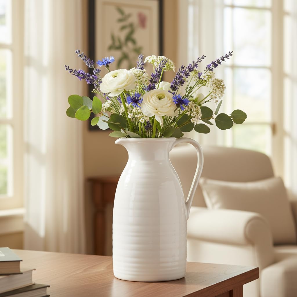 White pitcher with flowers on a table in a bright room