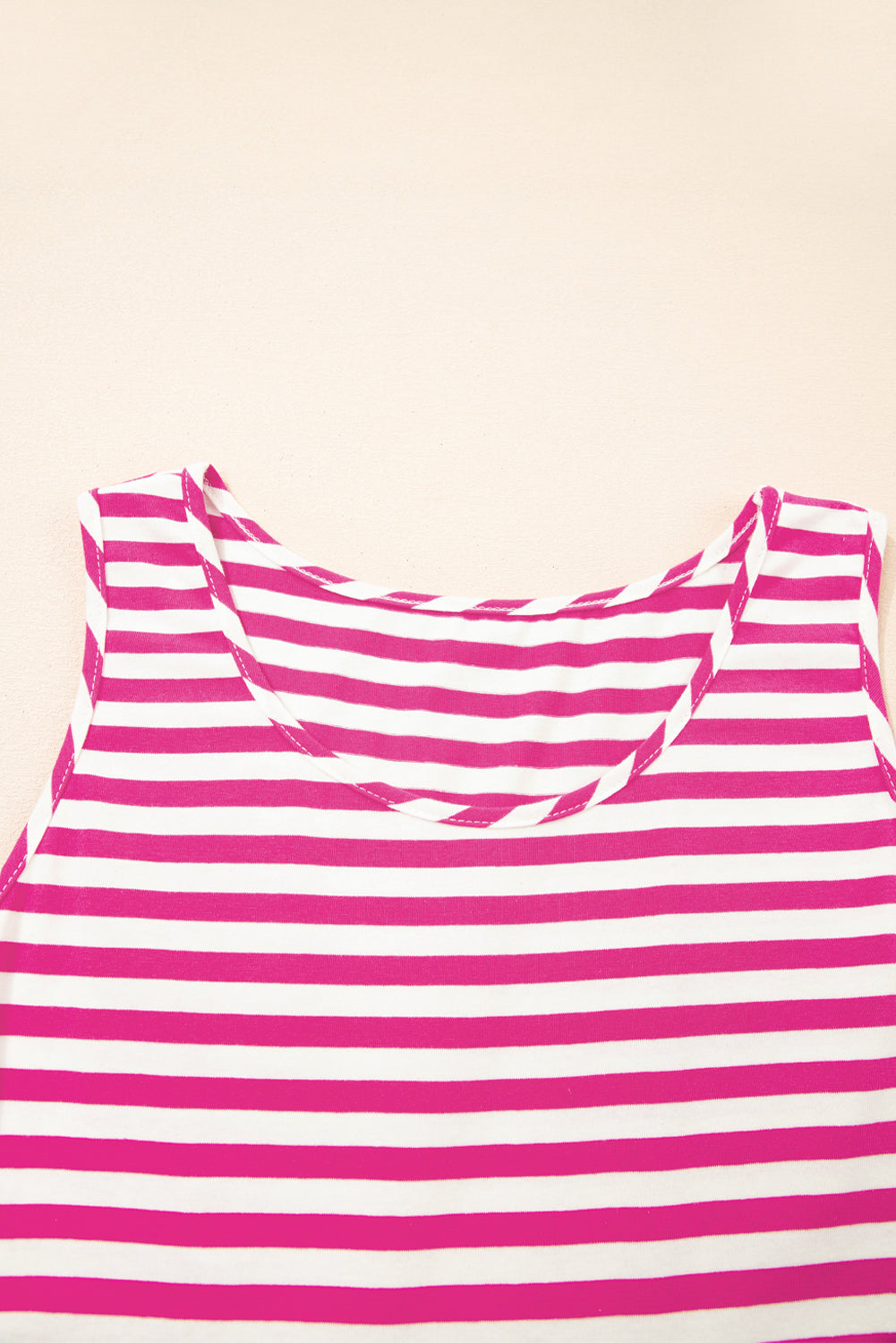 Pink and white striped tank top on a beige background
