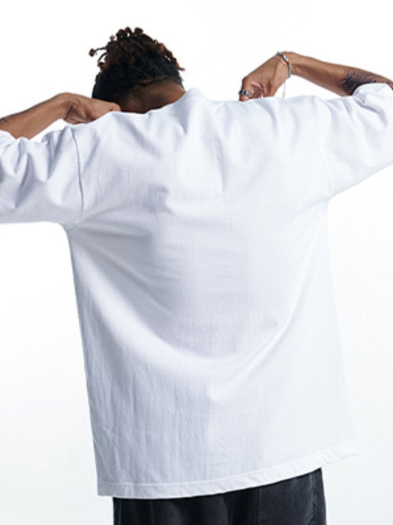 Person wearing a white shirt with arms raised, back to camera