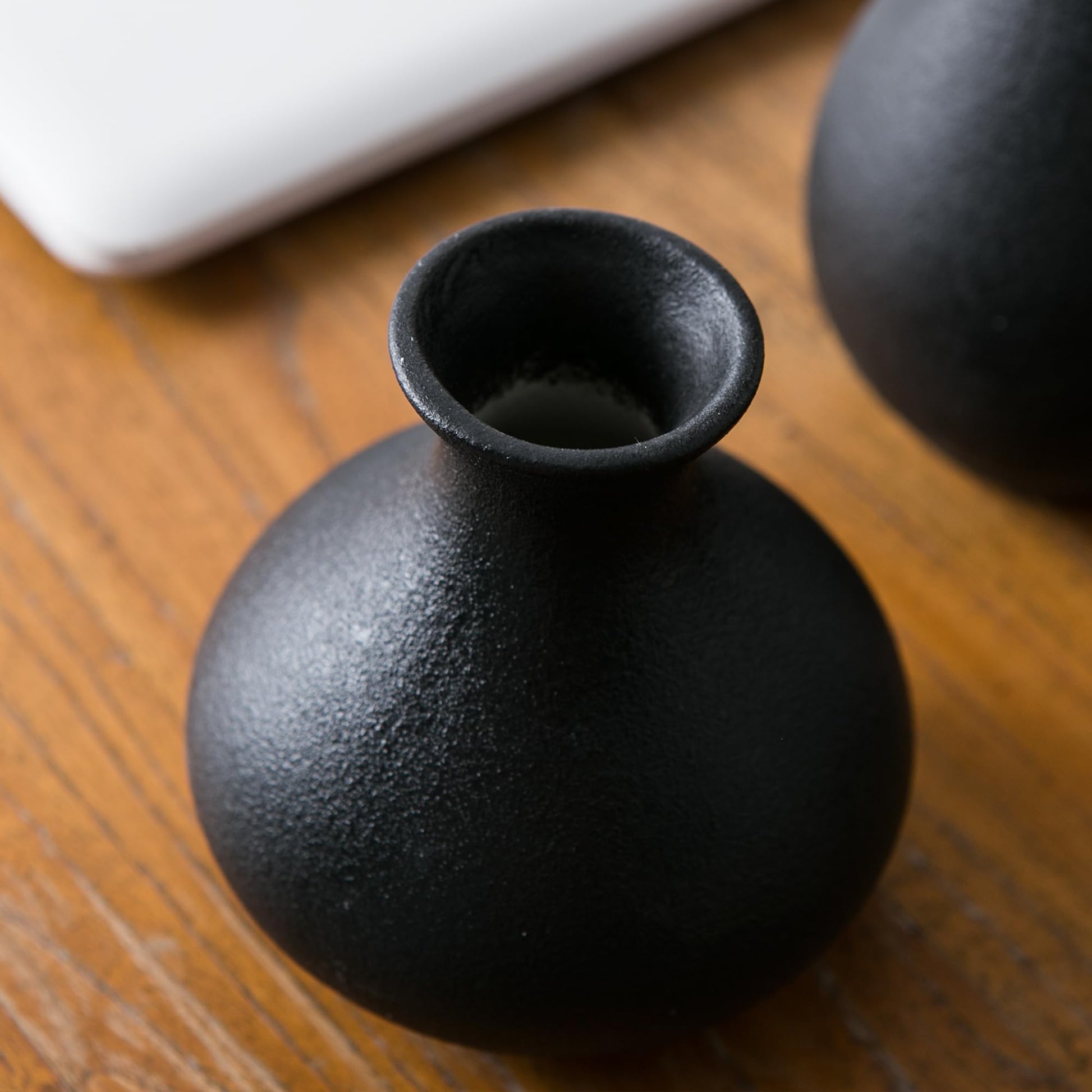 Black ceramic vase on a wooden surface