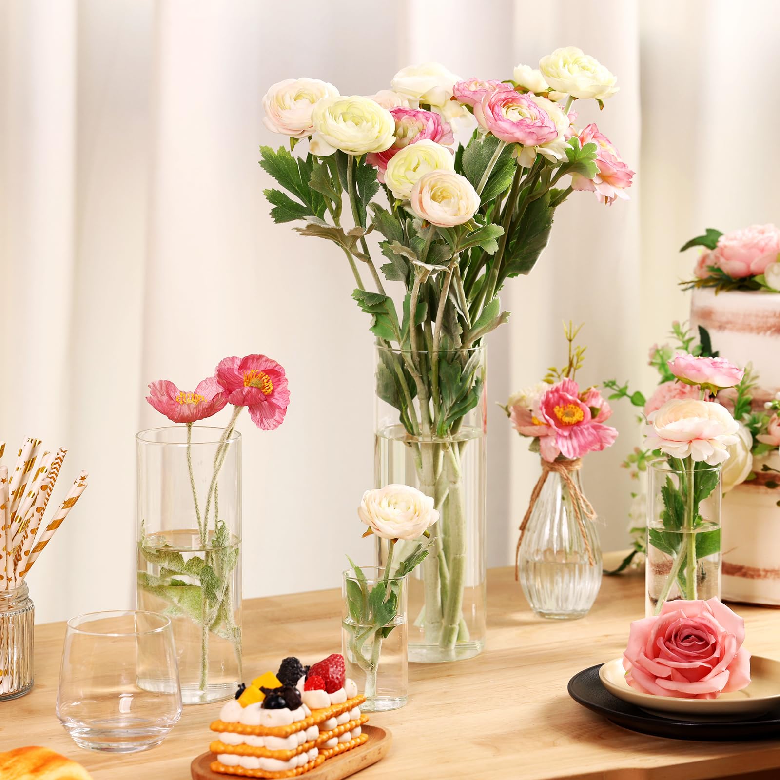 Decorative table setting with flowers in vases and a small cake.