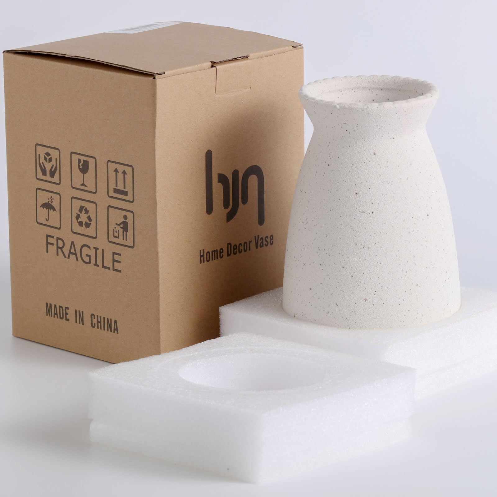 White ceramic vase next to its packaging box with 'hyu' branding on a light gray background