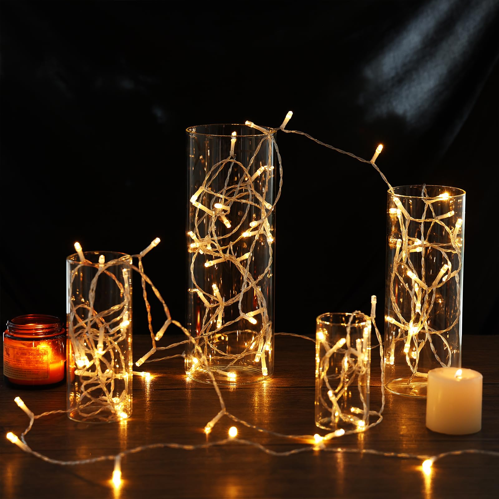 Decorative glass vases with string lights on a dark background