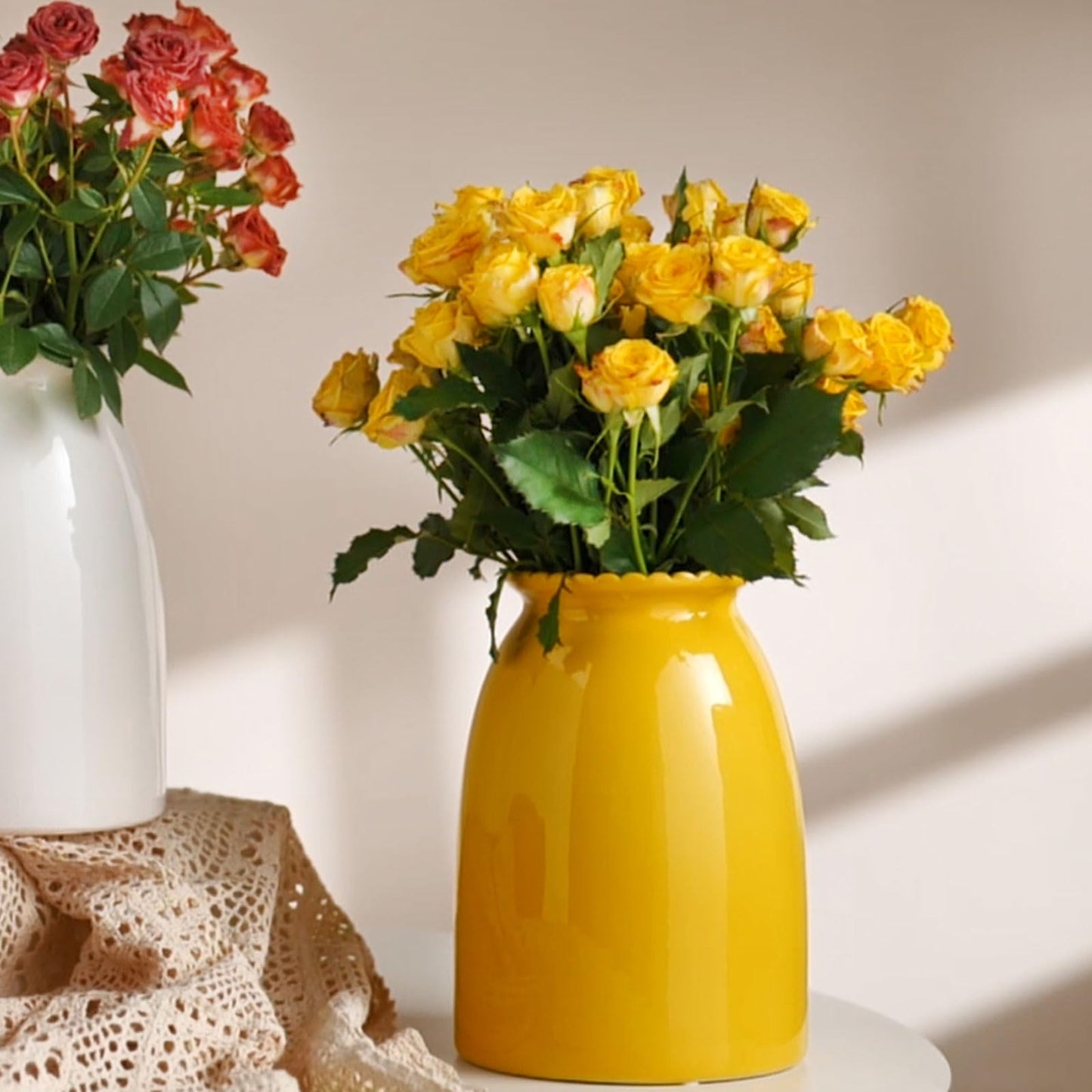 Yellow vase with flowers on a table with a white background