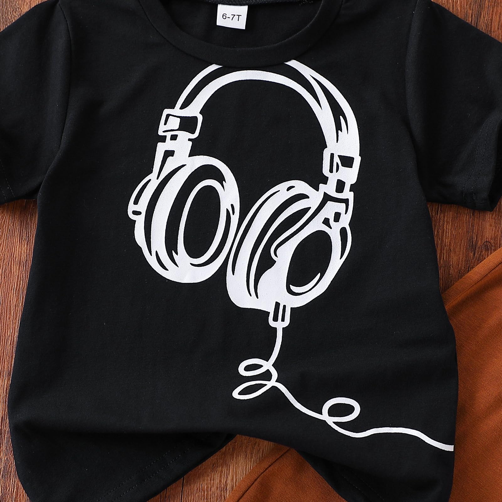Black t-shirt with white headphones design on a wooden surface