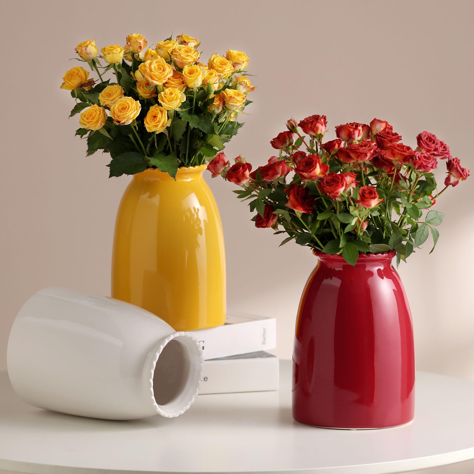 Two vases with yellow and red flowers on a neutral background
