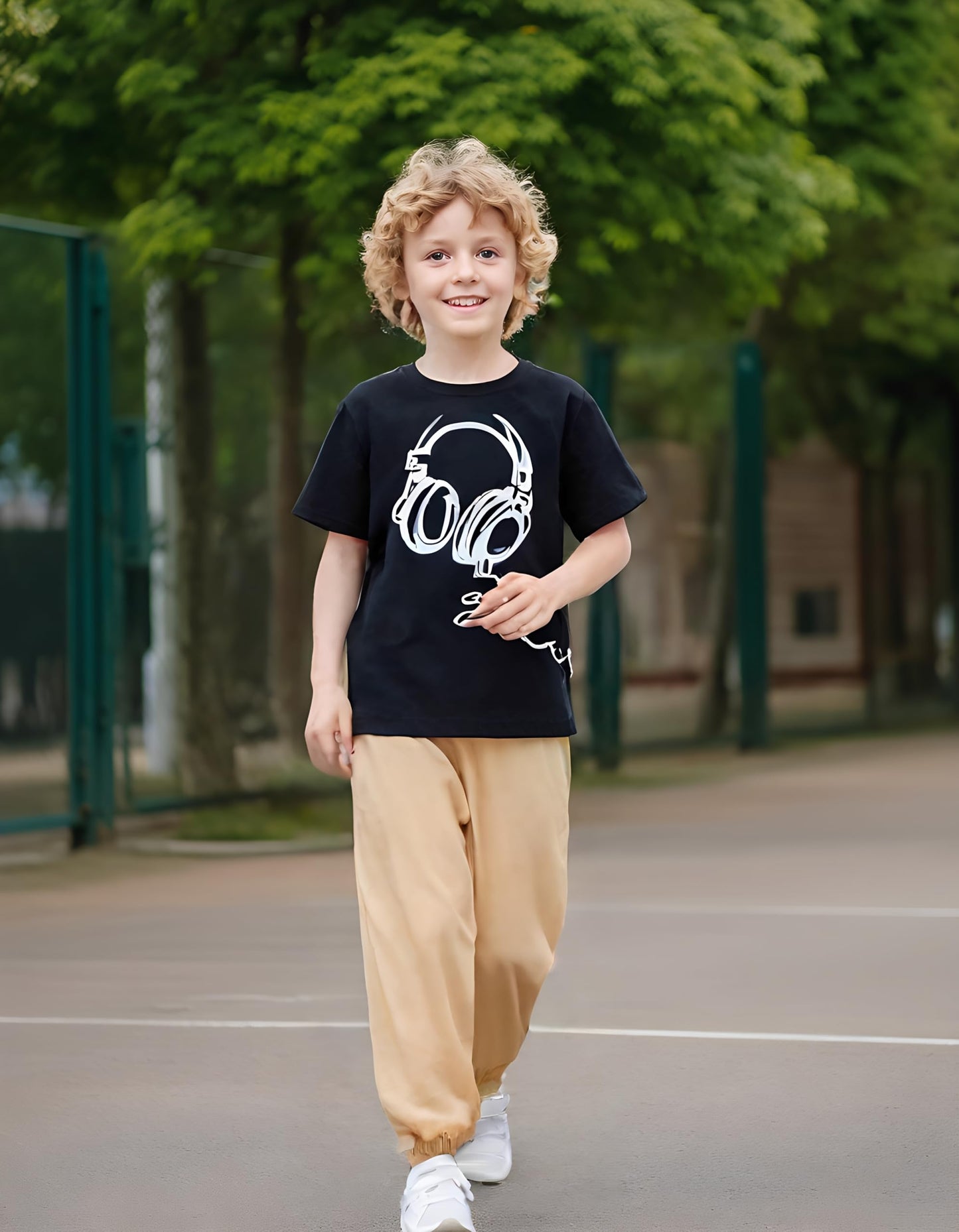 Child wearing a black t-shirt with a white graphic design outdoors on a playground.