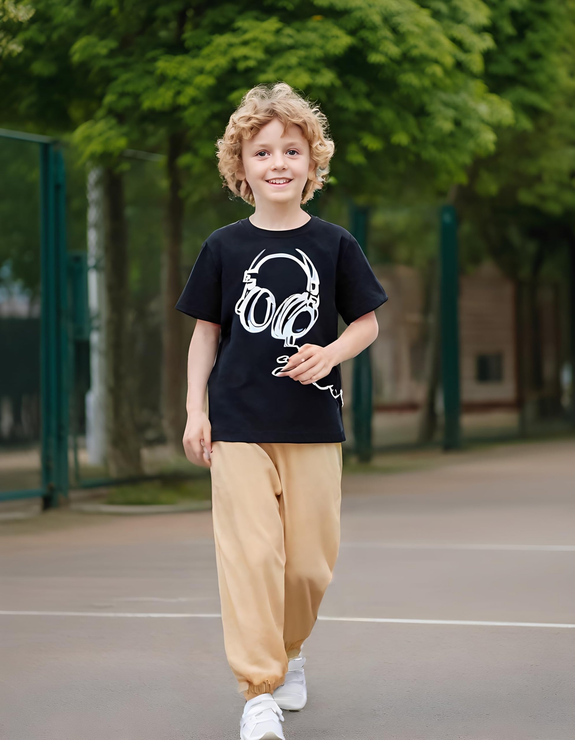 Child wearing a black t-shirt with a white graphic design outdoors on a playground.