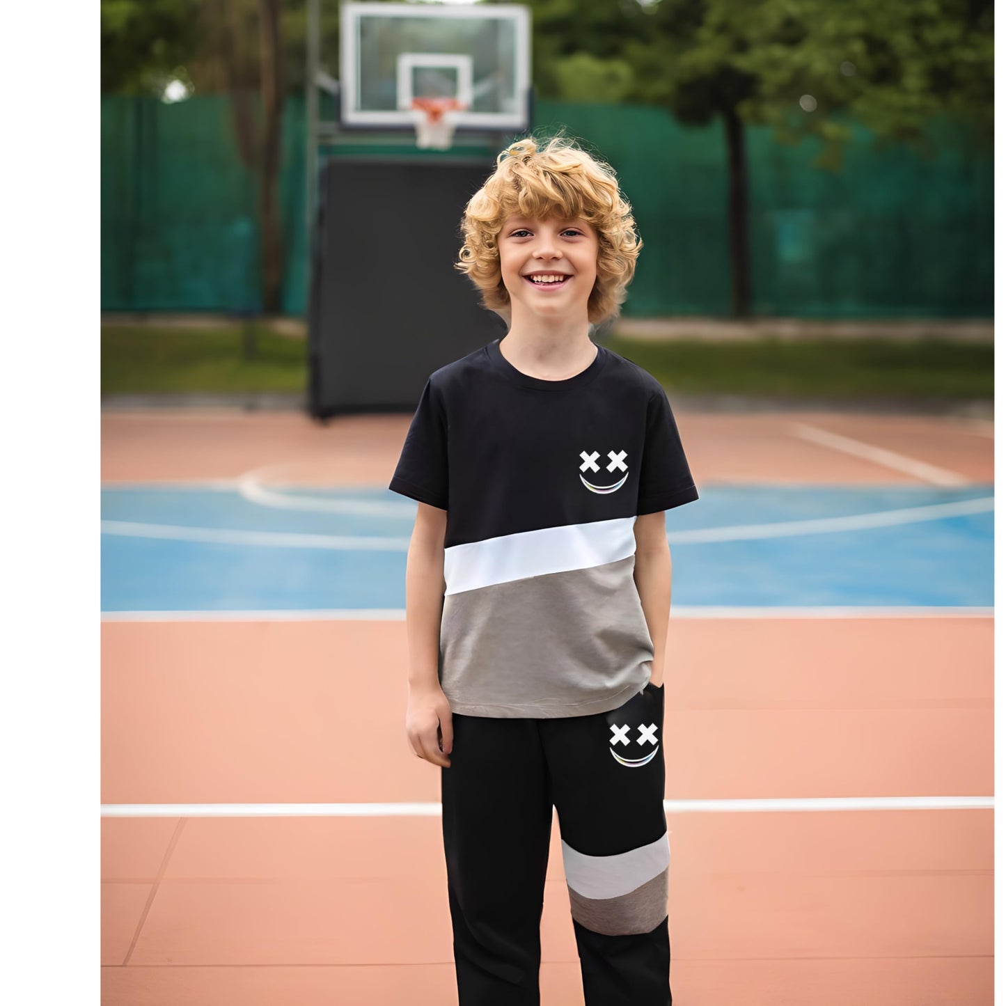 Child wearing a black and gray outfit with smiley face designs on a basketball court
