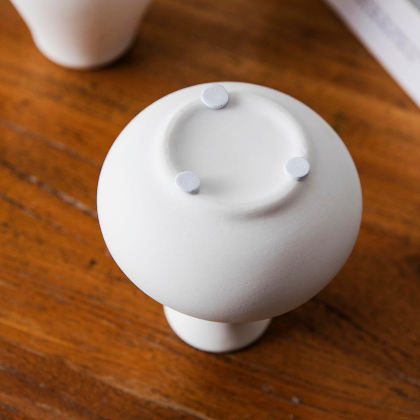White ceramic knob on a wooden surface