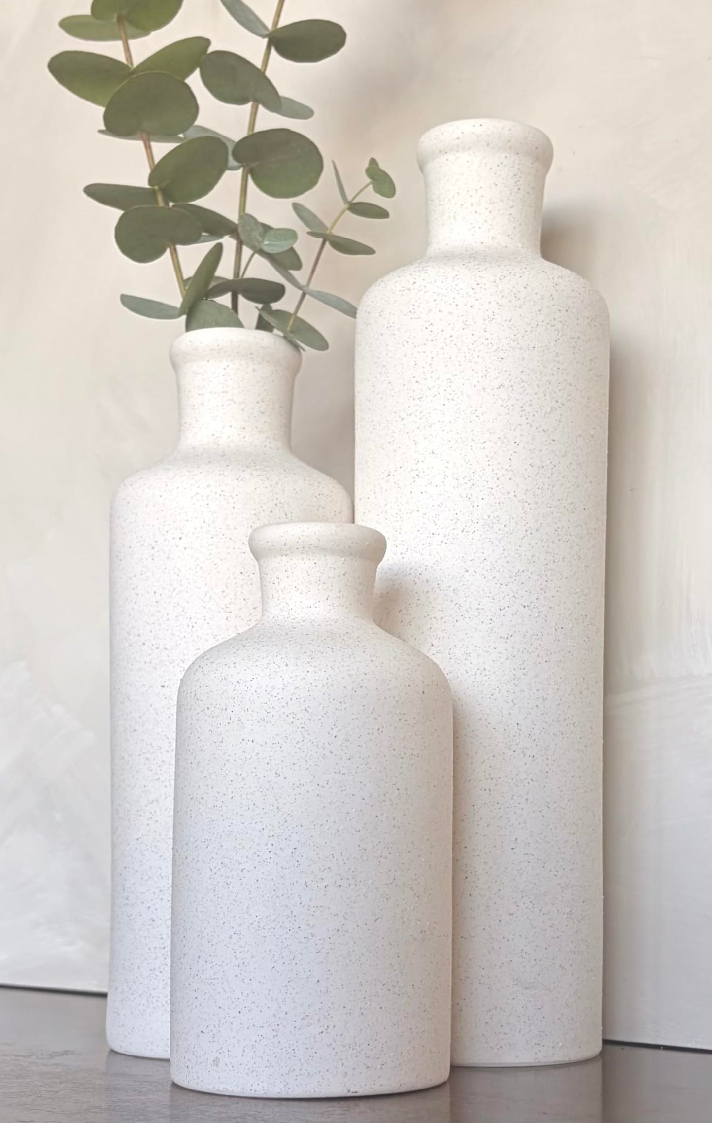 Three white textured vases on a light background