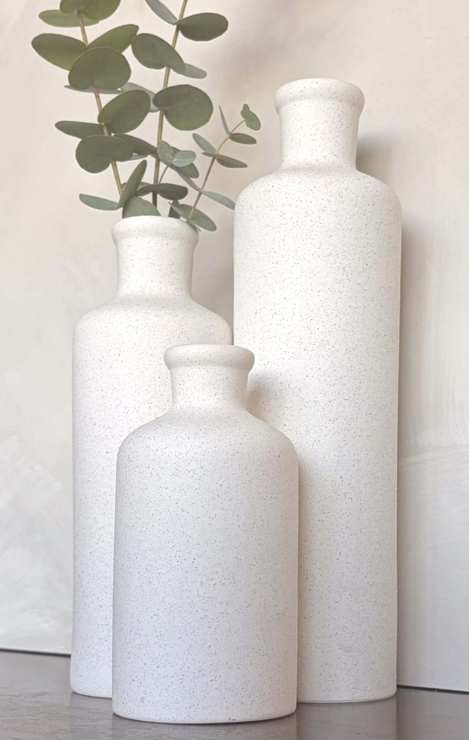 Three white textured vases on a light background