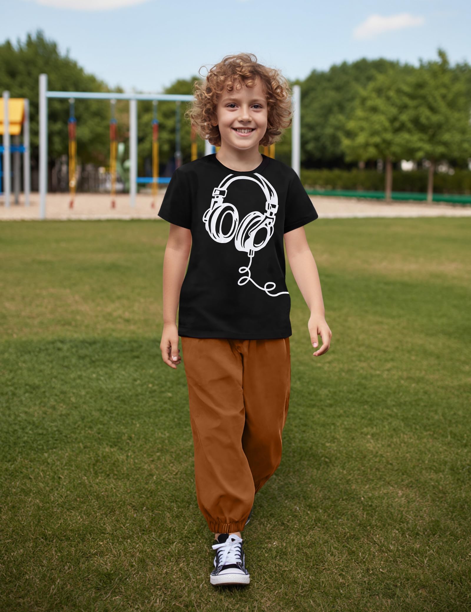Child wearing a black t-shirt with a white graphic design outdoors on grass