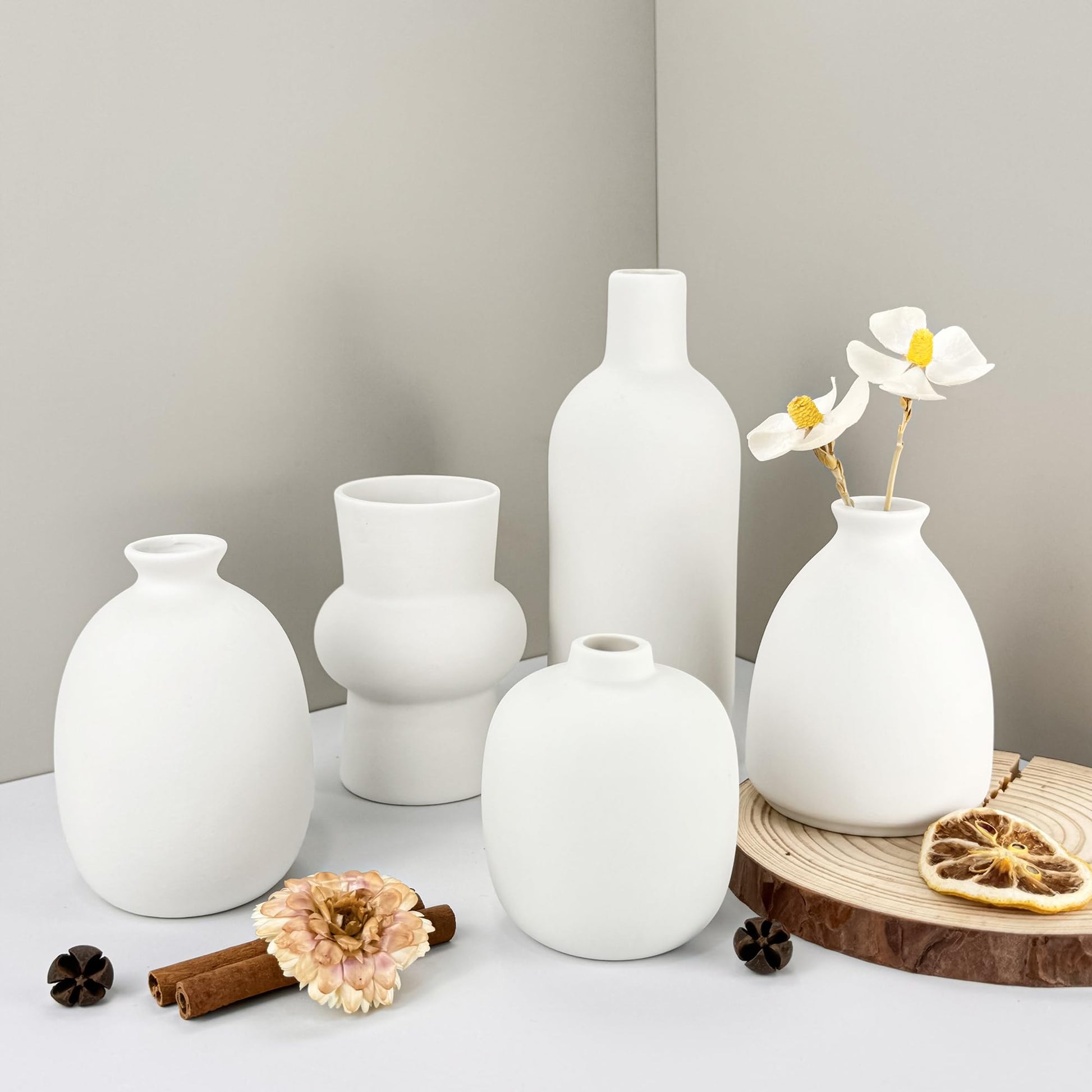 Set of white vases on a neutral background with decorative elements.