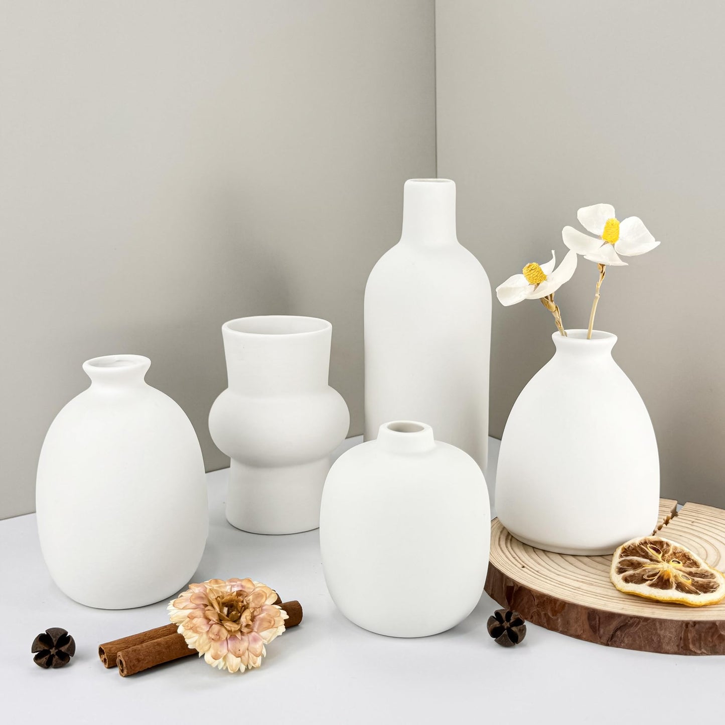 Set of white vases on a neutral background with decorative elements.