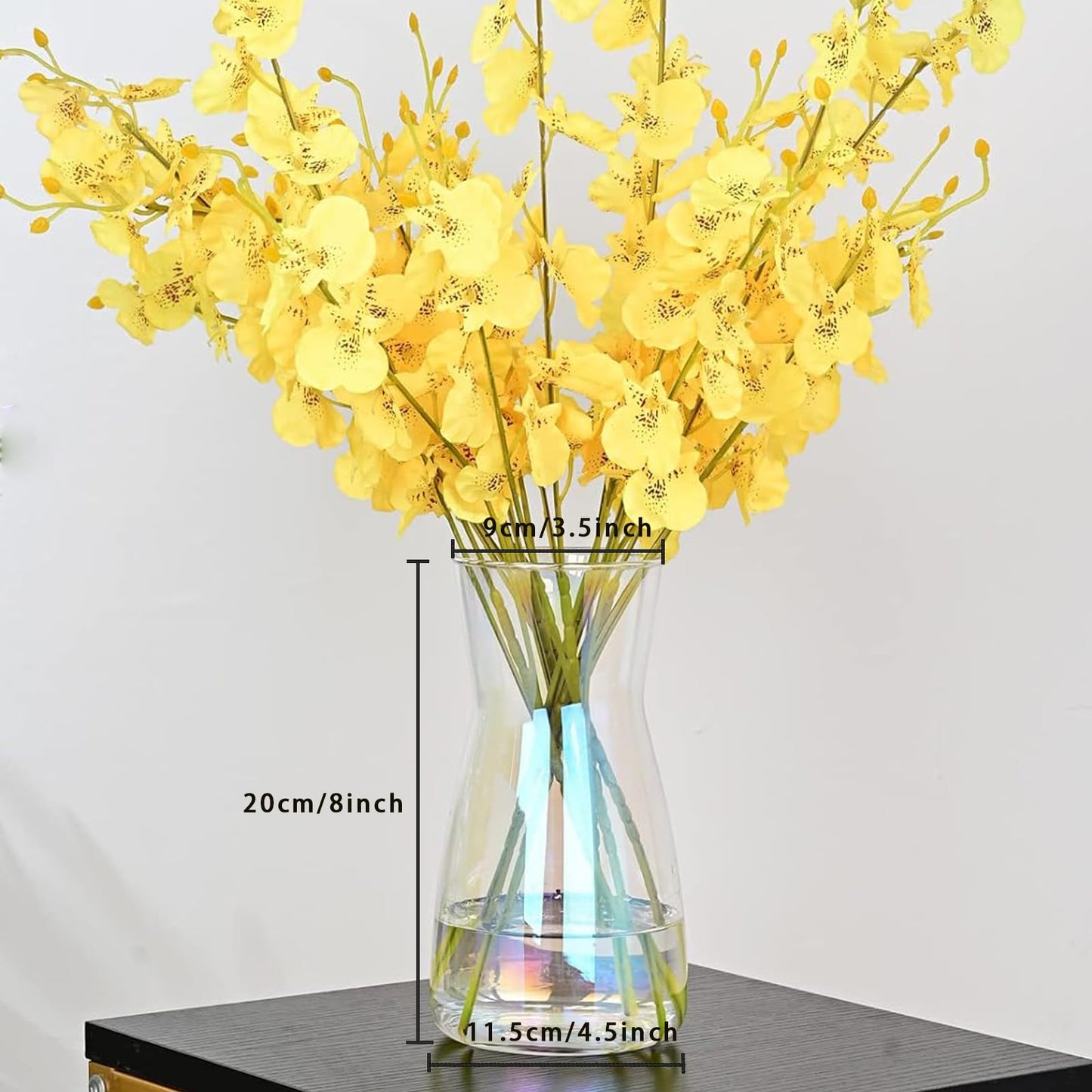 Yellow flowers in a clear vase with measurements on a white background