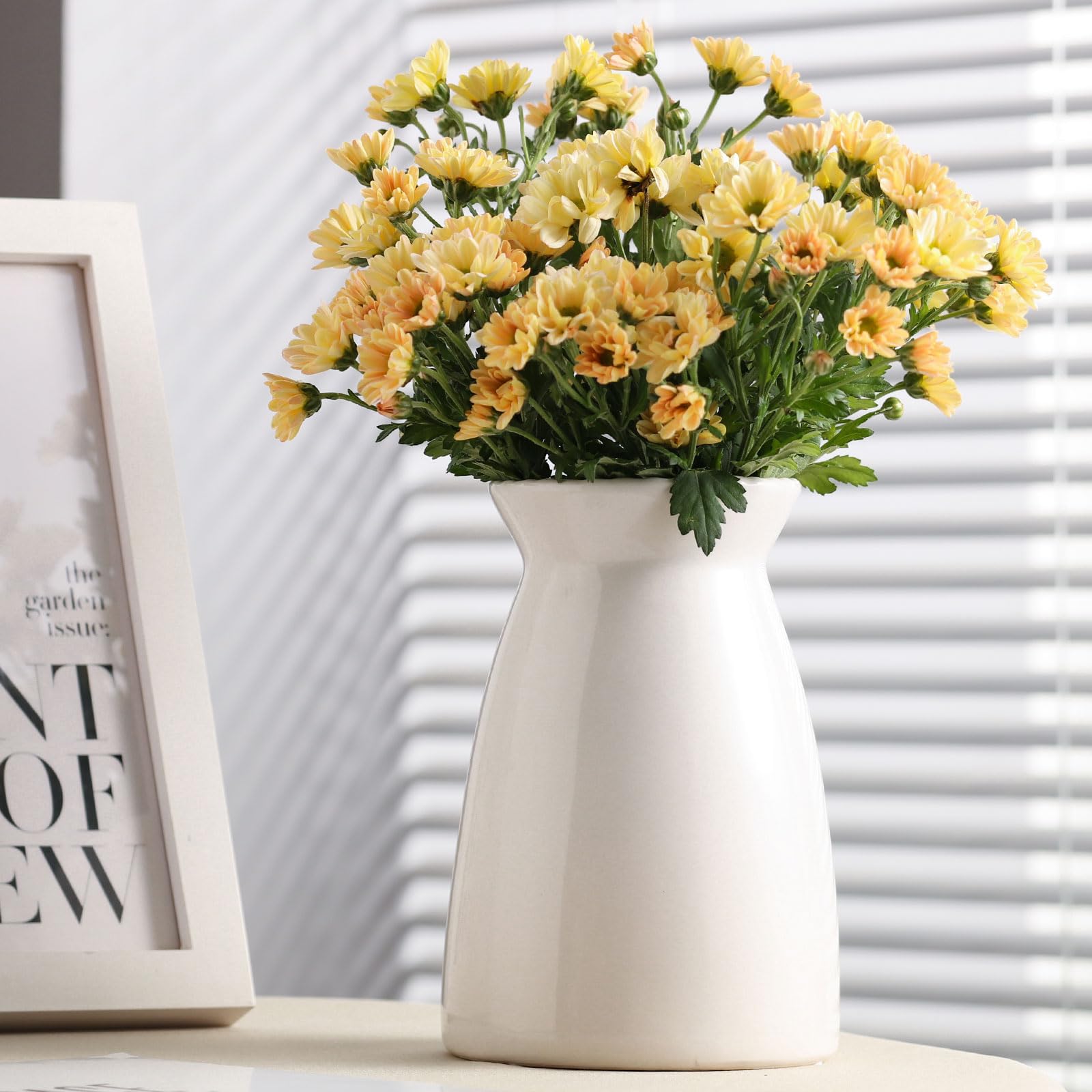 White vase with yellow flowers on a surface with a blurred background