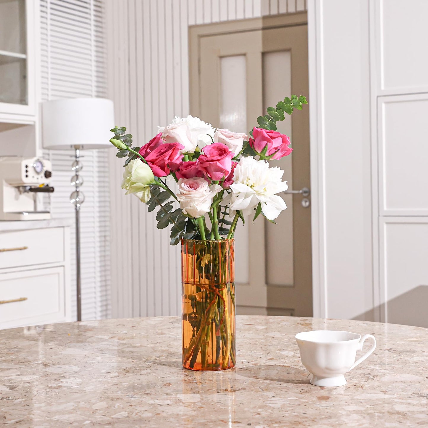 Vase with pink and white flowers on a kitchen counter