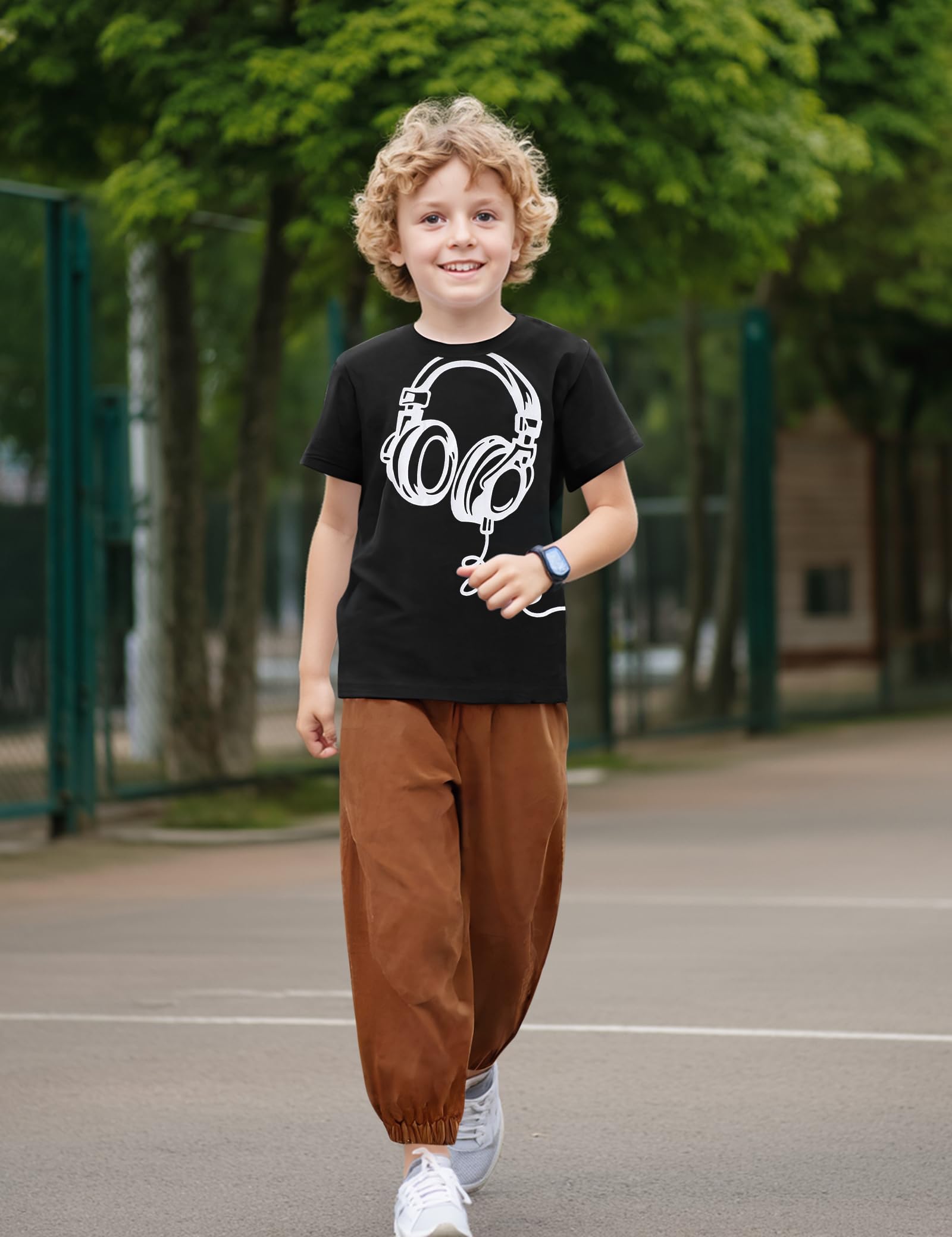 Child wearing a black t-shirt with a white graphic design outdoors on a playground.