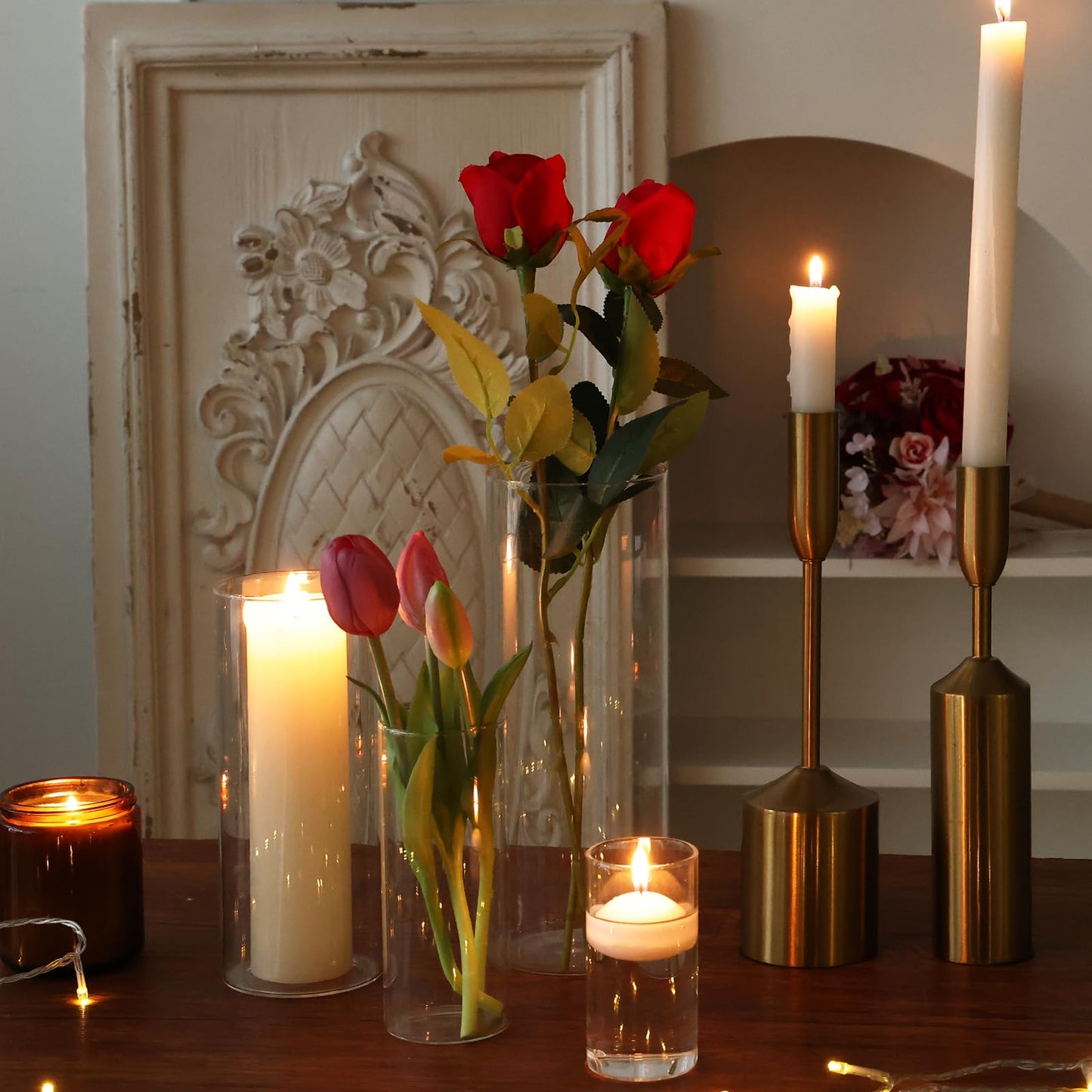 Decorative setup with candles and flowers on a wooden surface.