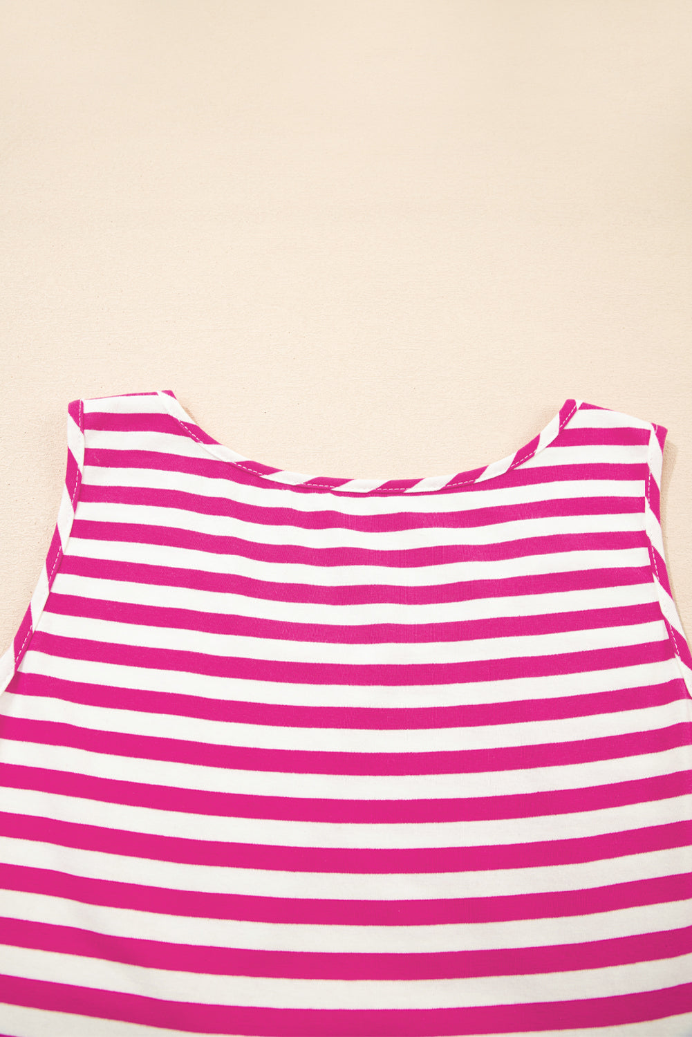 Pink and white striped top on a beige background