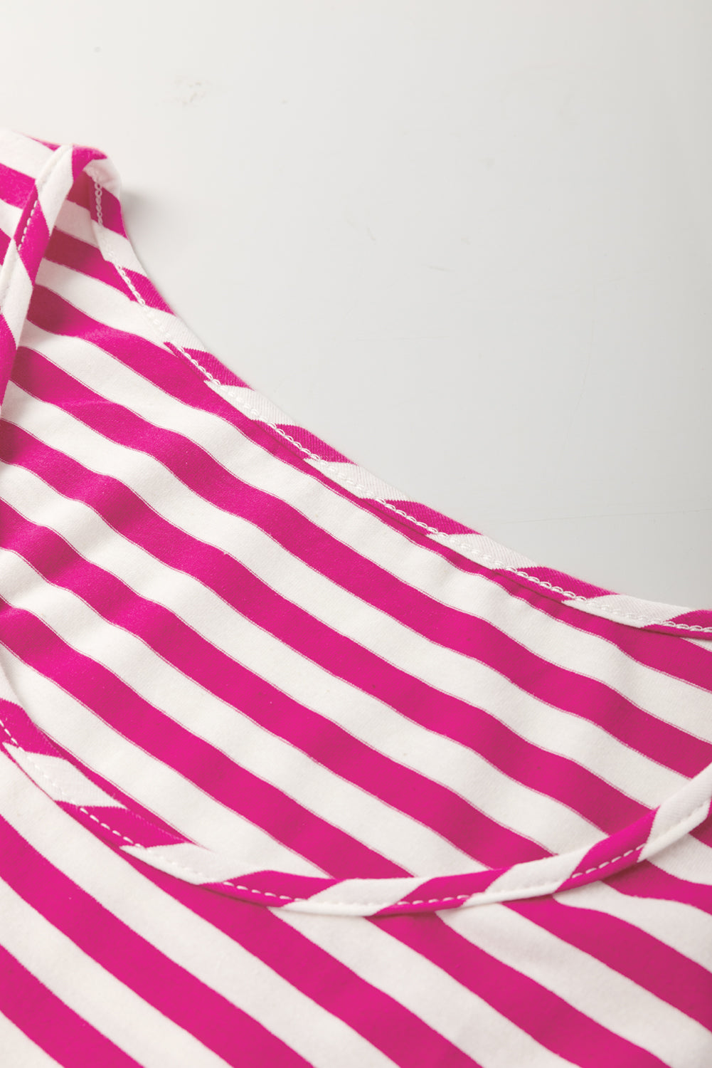 Pink and white striped fabric on a white background