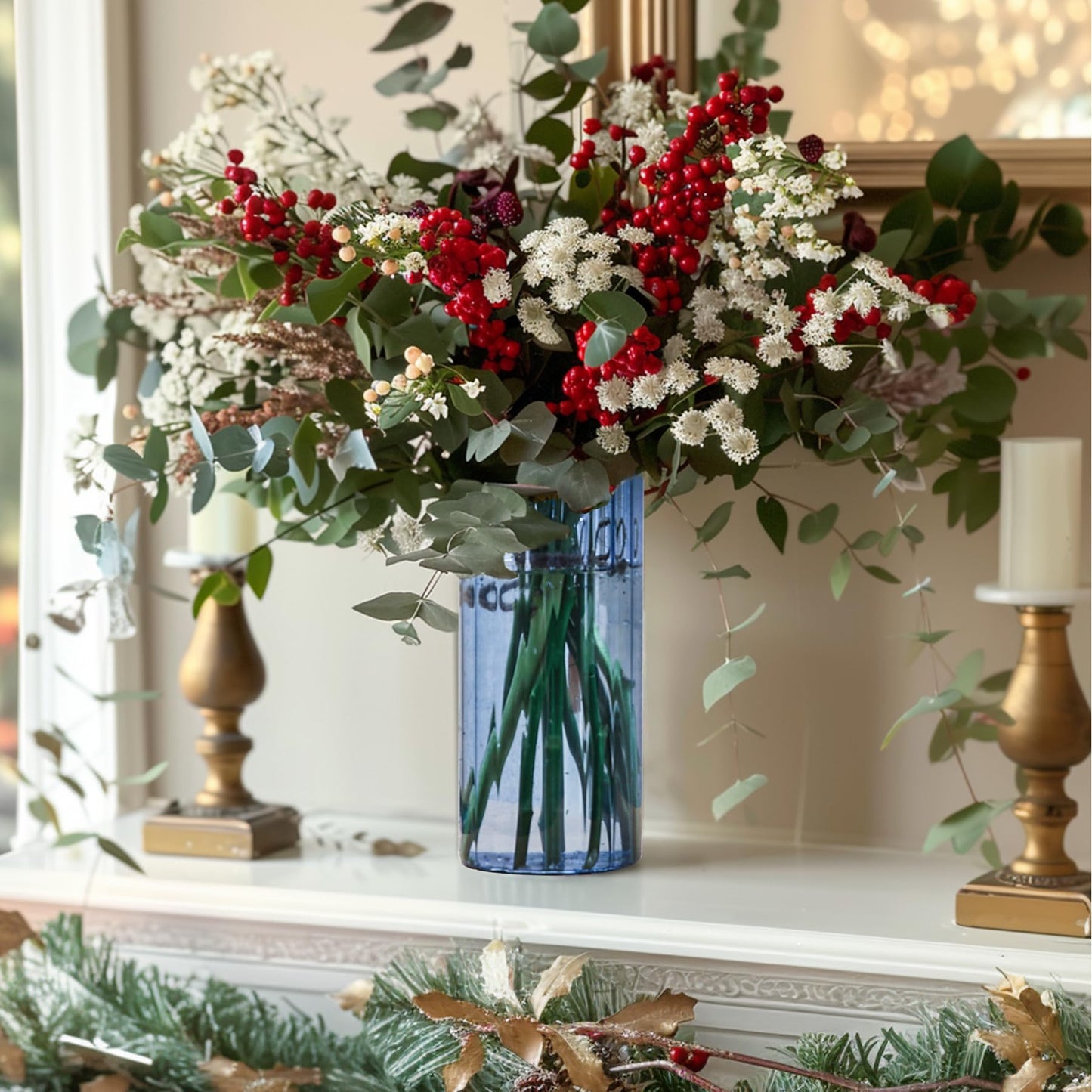 Decorative floral arrangement with red berries and green leaves in a blue vase on a mantelpiece.
