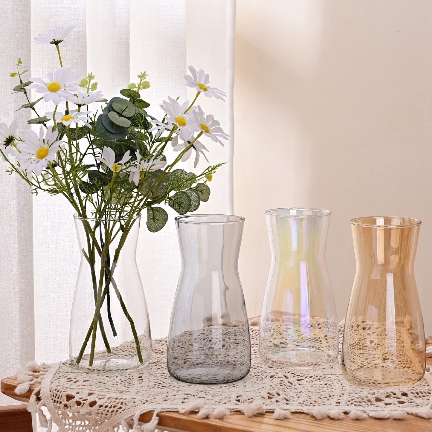 Set of glass vases with flowers on a lace tablecloth
