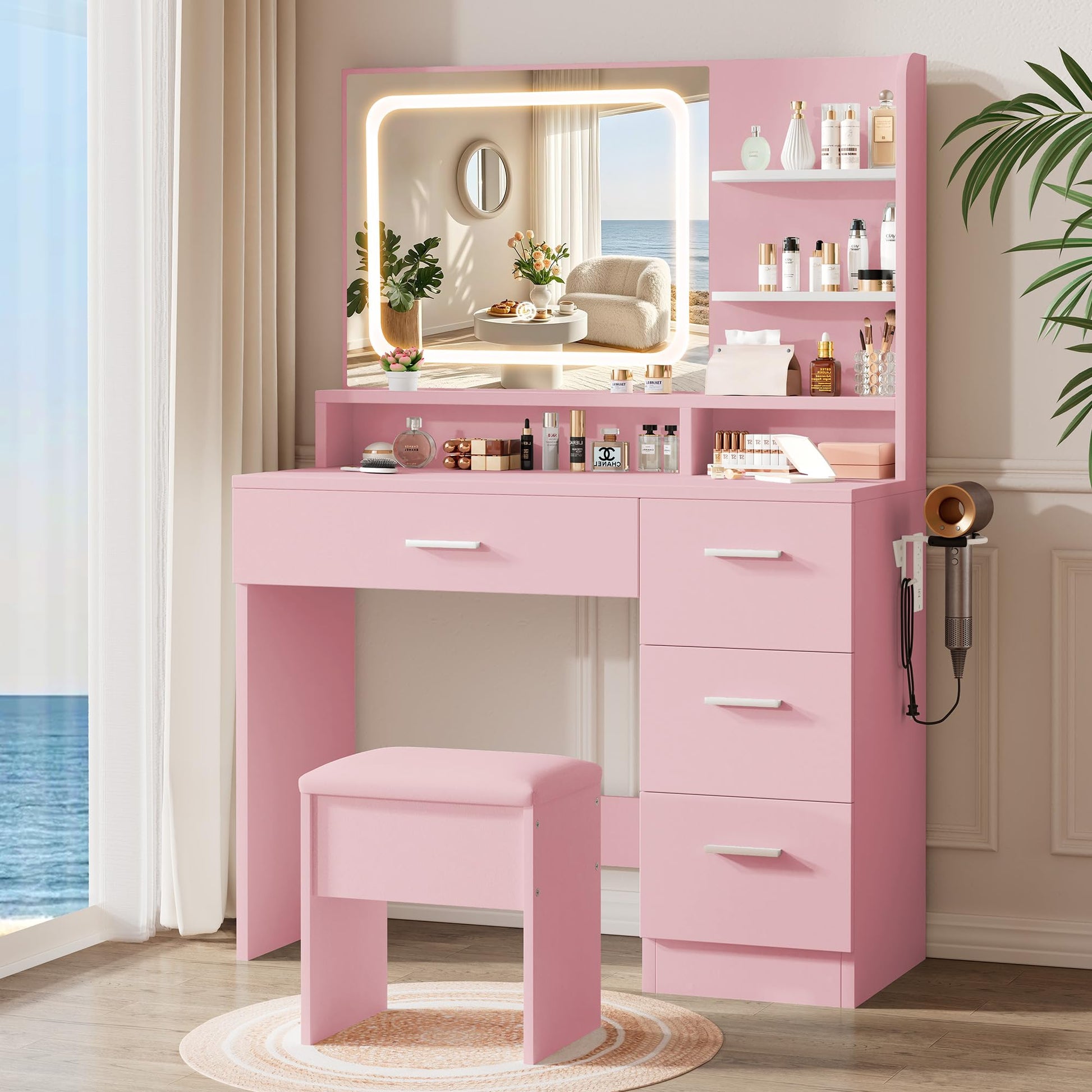 Pink vanity table with mirror, lights, and various items in a bright room.