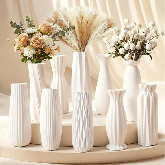 Set of white vases with floral arrangements on a neutral background