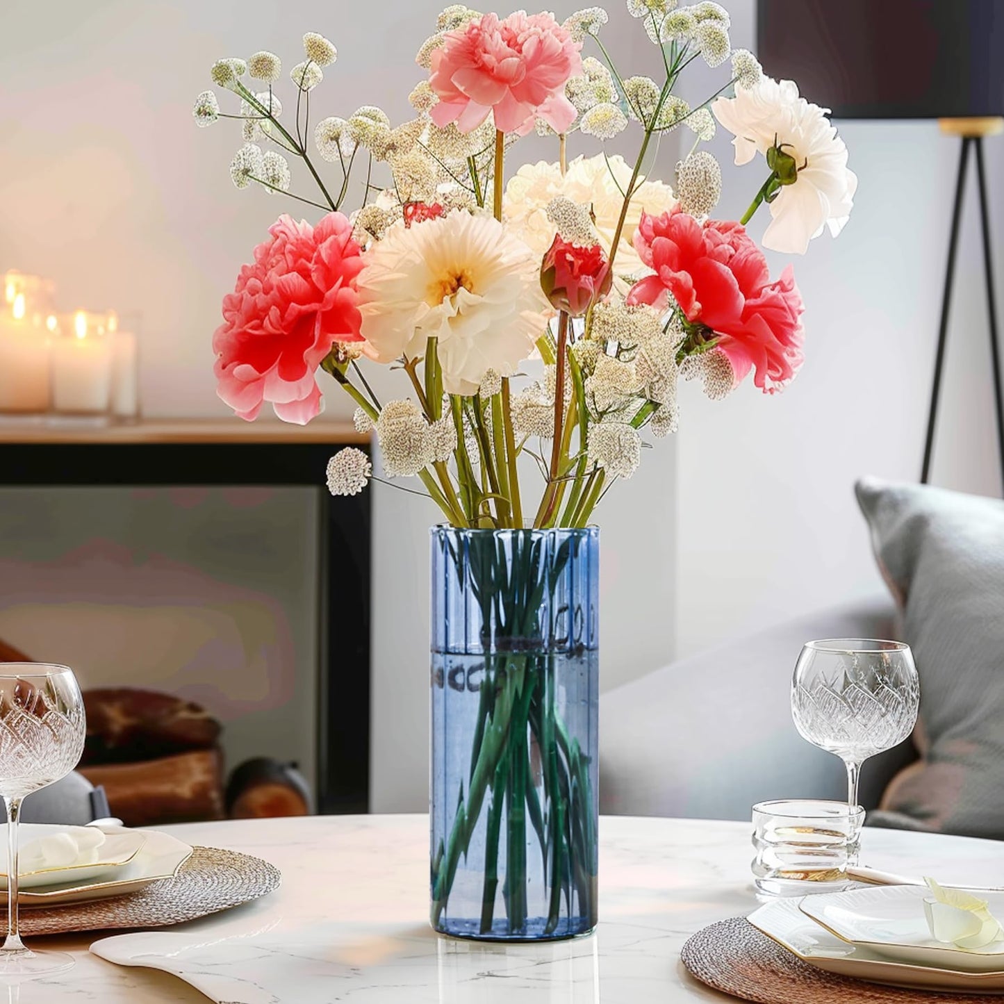Decorative table setting with a vase of flowers and wine glasses.