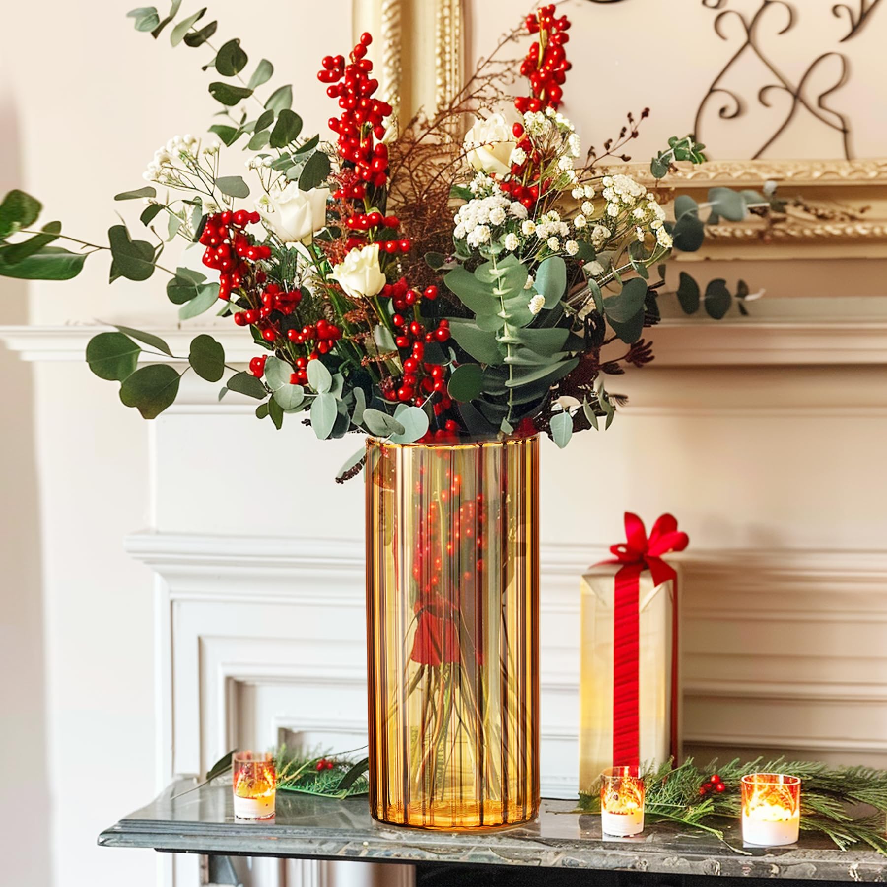 Decorative floral arrangement with red berries and green leaves in a gold vase on a mantelpiece with candles and a gift.