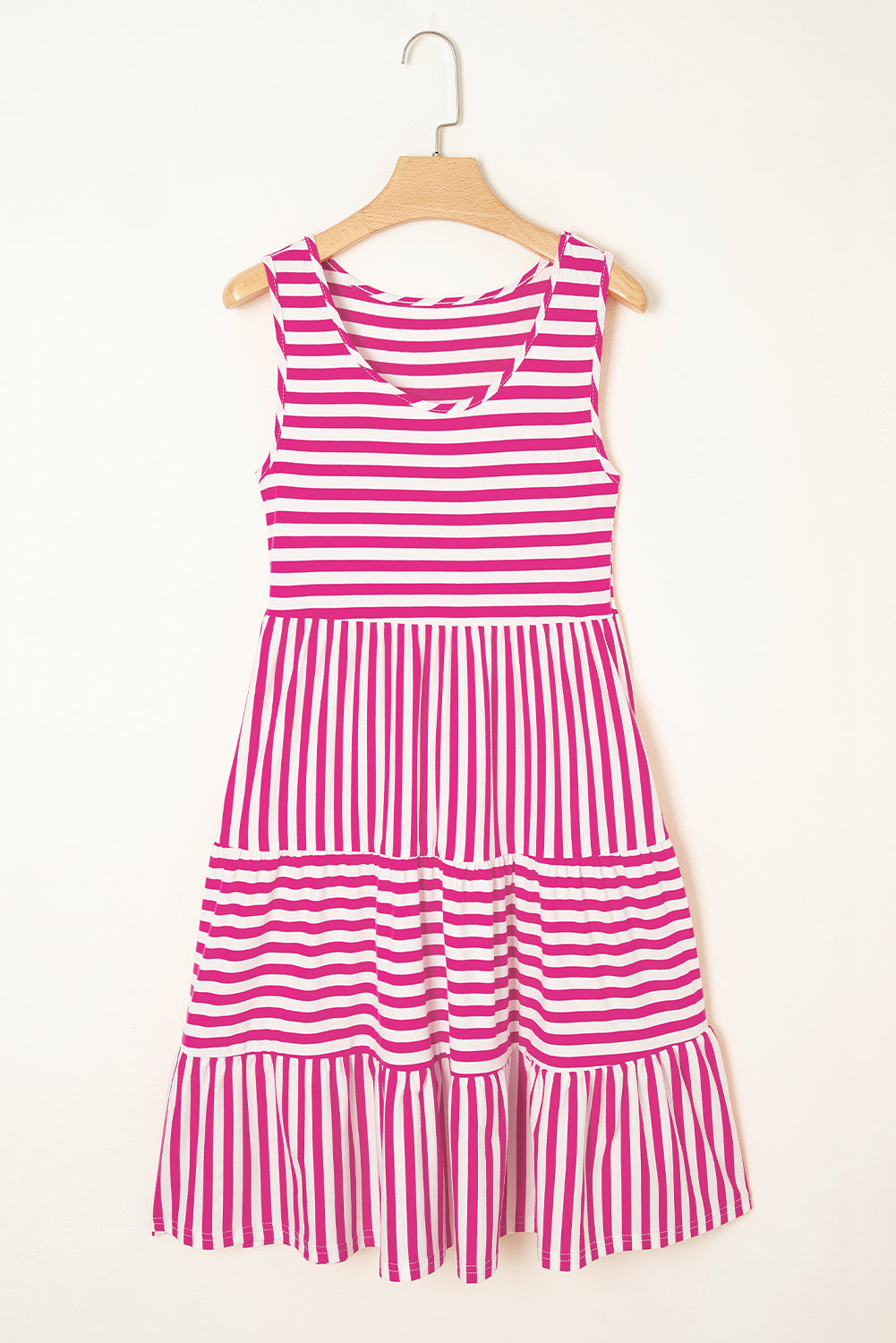 Pink and white striped dress on a hanger against a white background