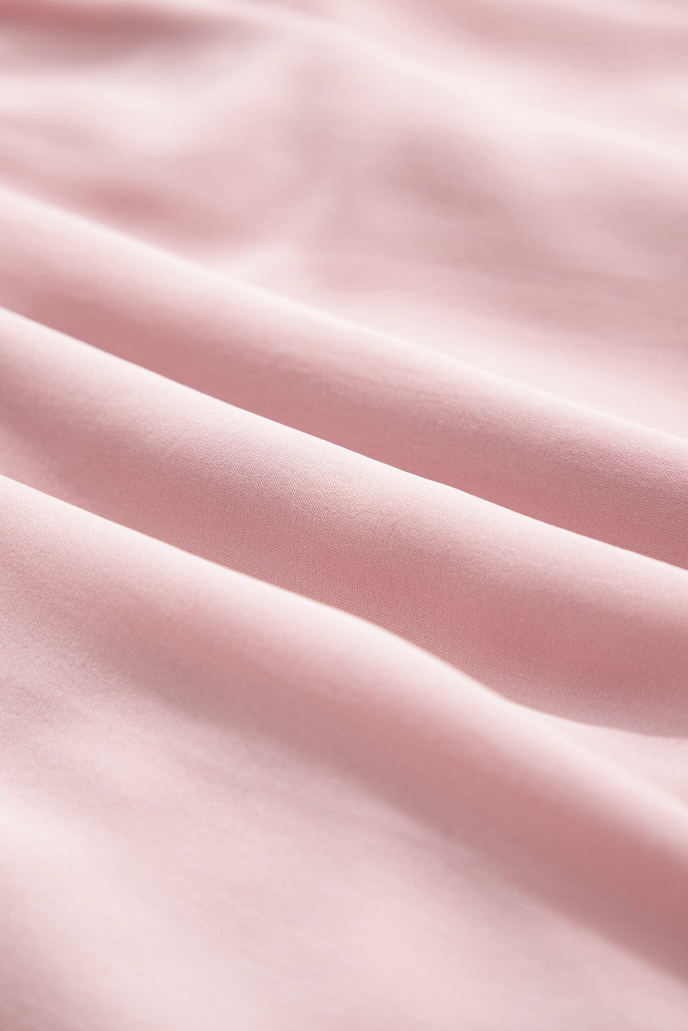 Close-up of smooth pink fabric with soft folds