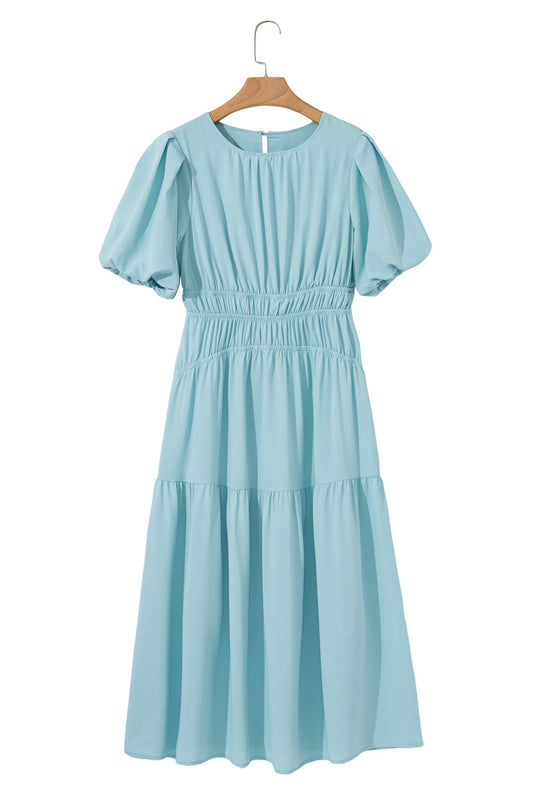 Light blue dress on a wooden hanger against a white background