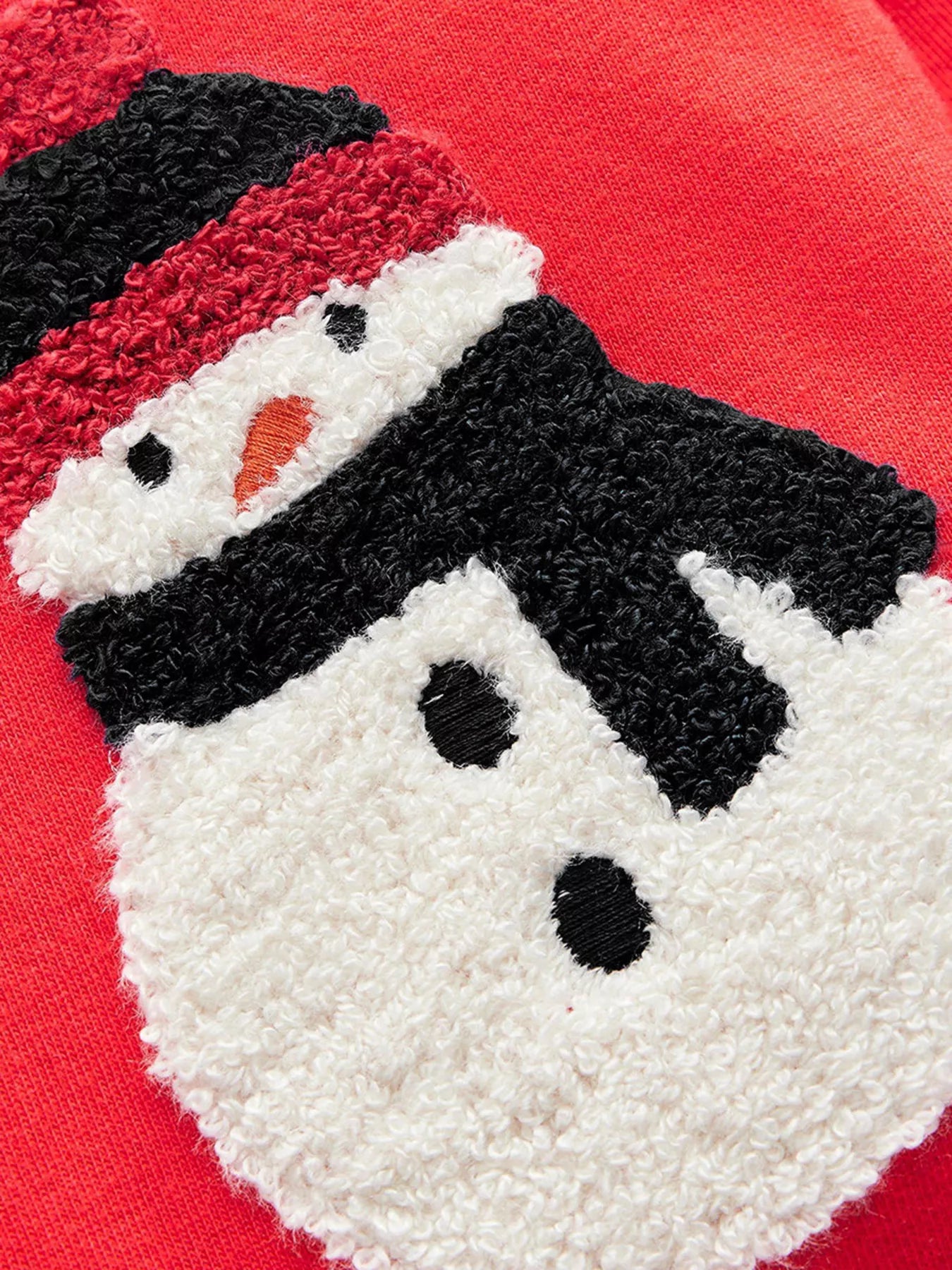 Close-up of a textured snowman design on a red background